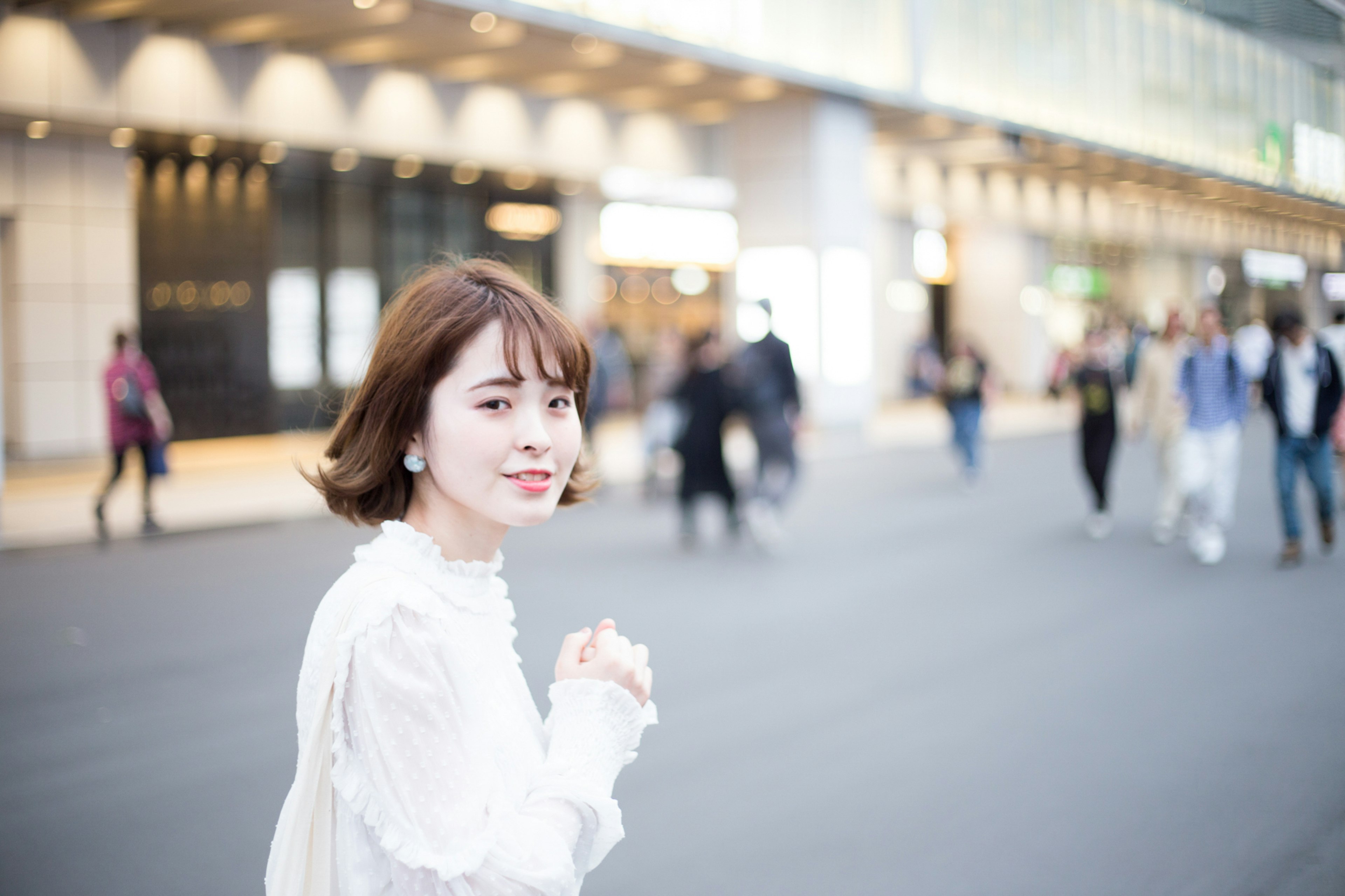 Portrait of a smiling woman in the city background with people walking