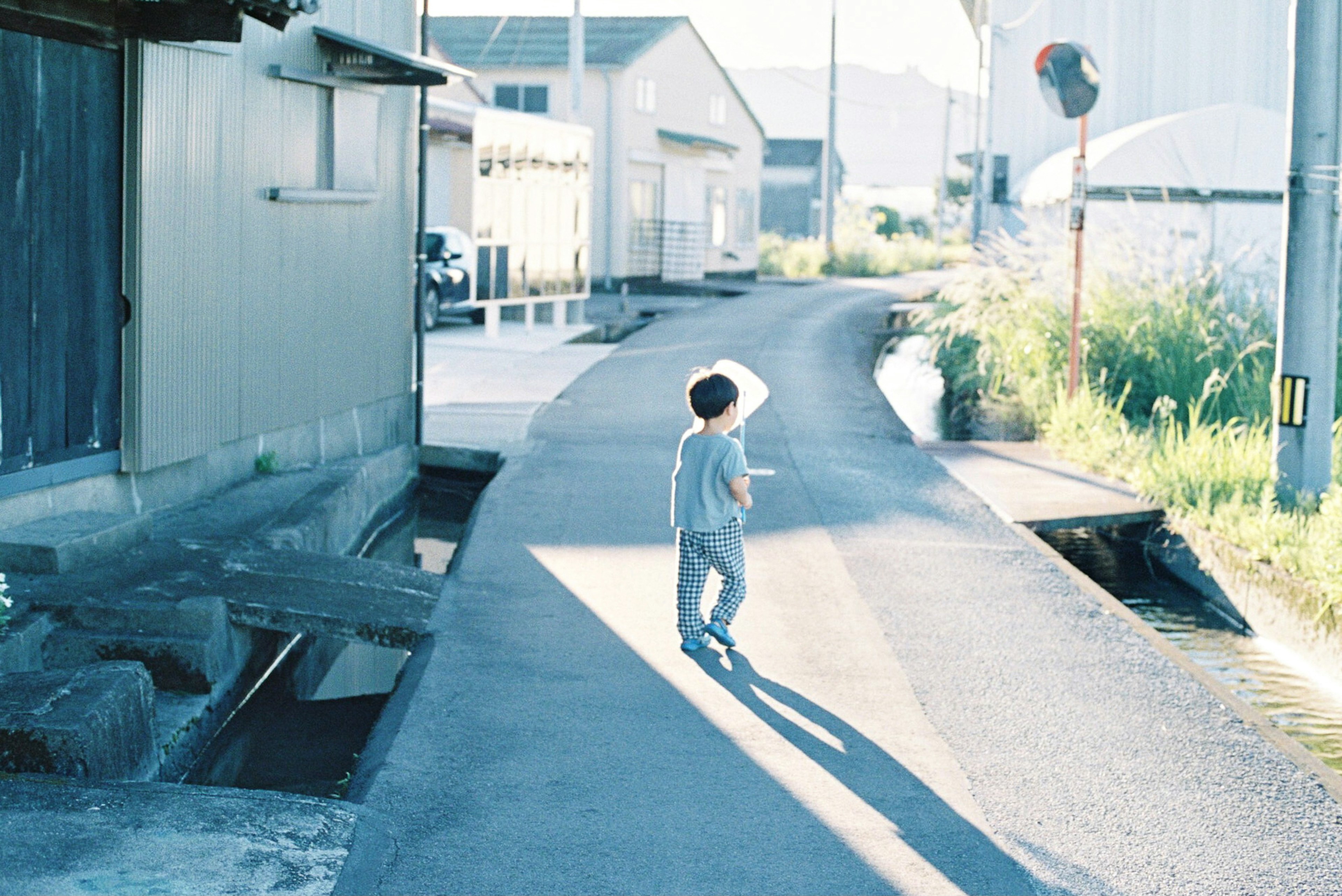 Niño caminando por un camino estrecho con edificios cercanos