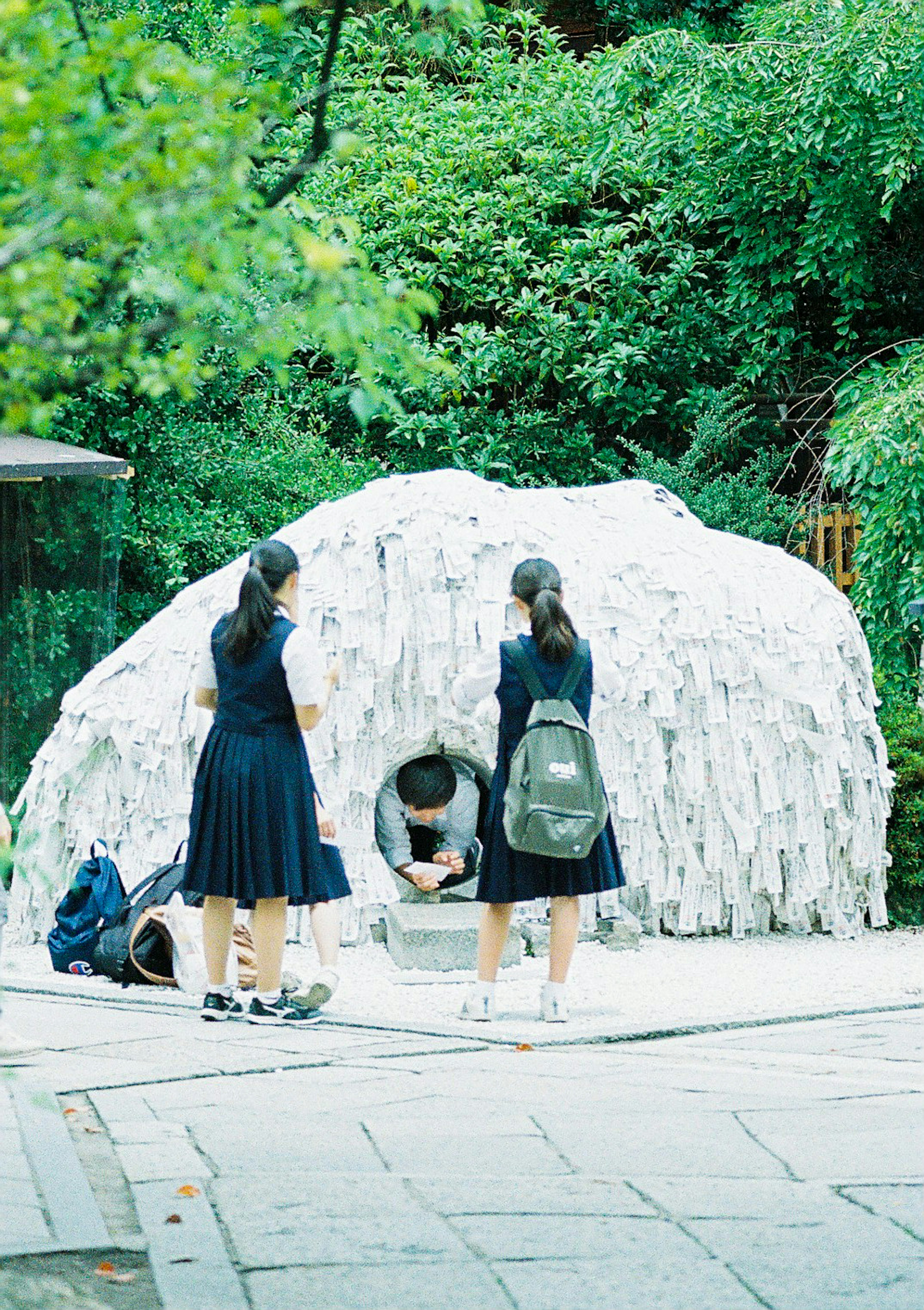 Étudiants devant une sculpture recouverte de tissu blanc