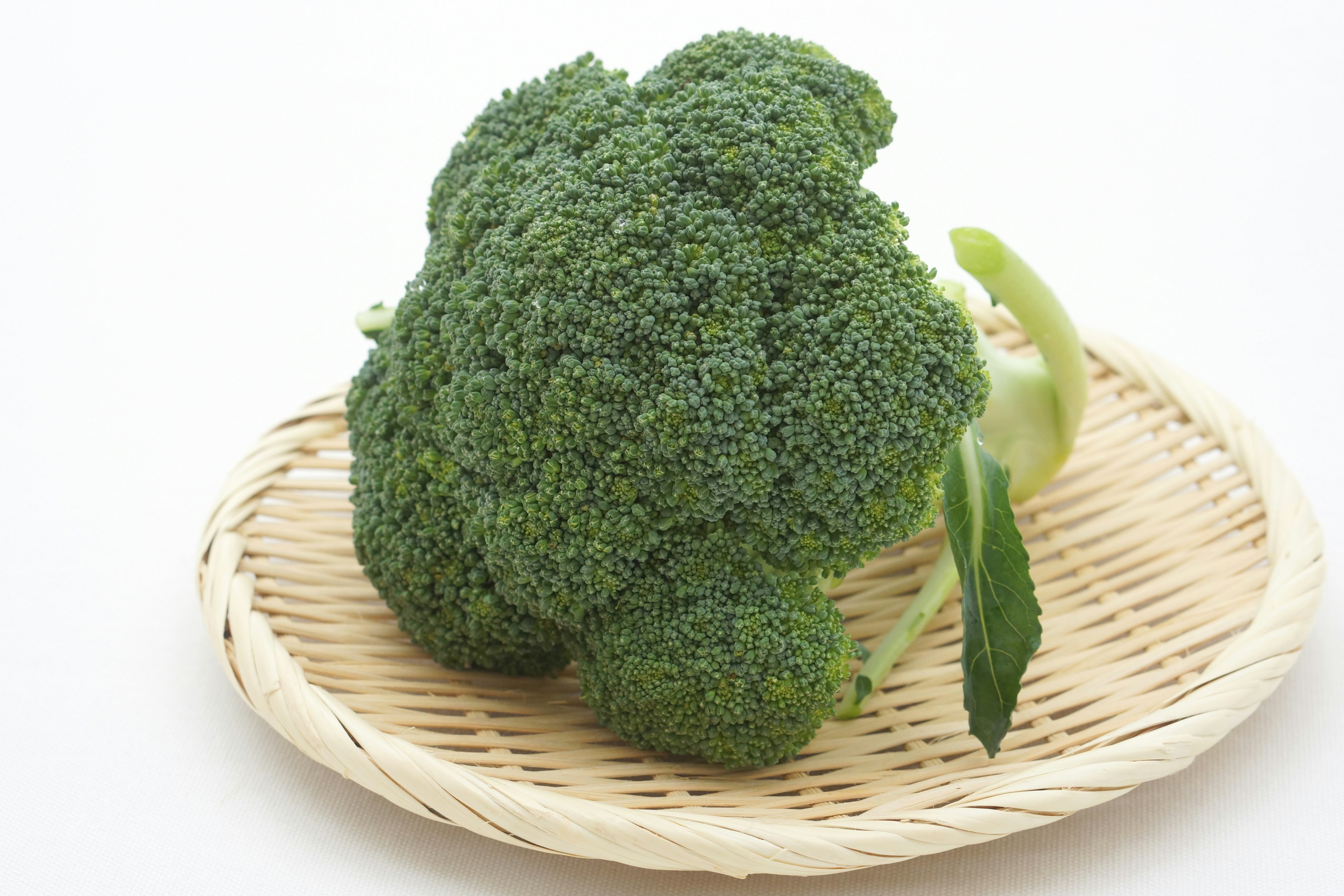 Fresh broccoli placed on a woven plate