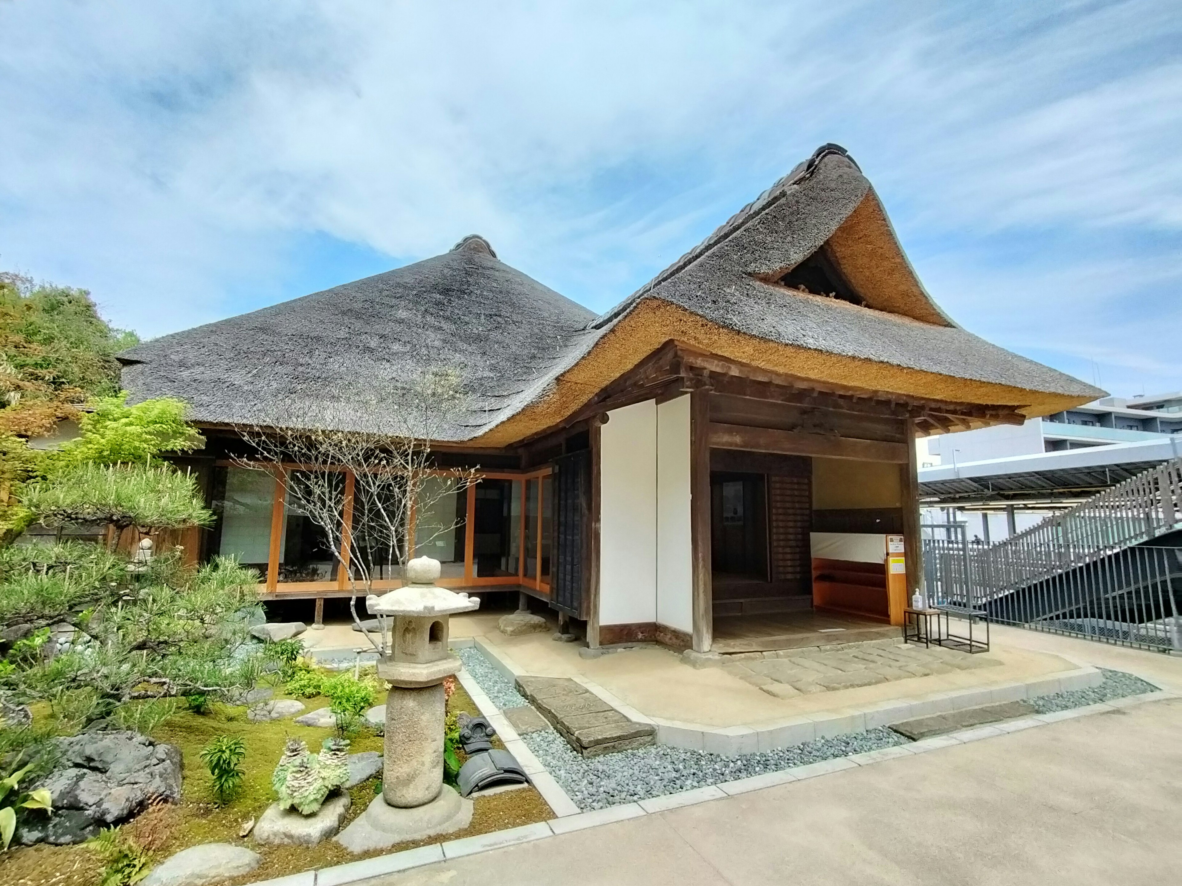 Casa japonesa tradicional con techo de paja y jardín