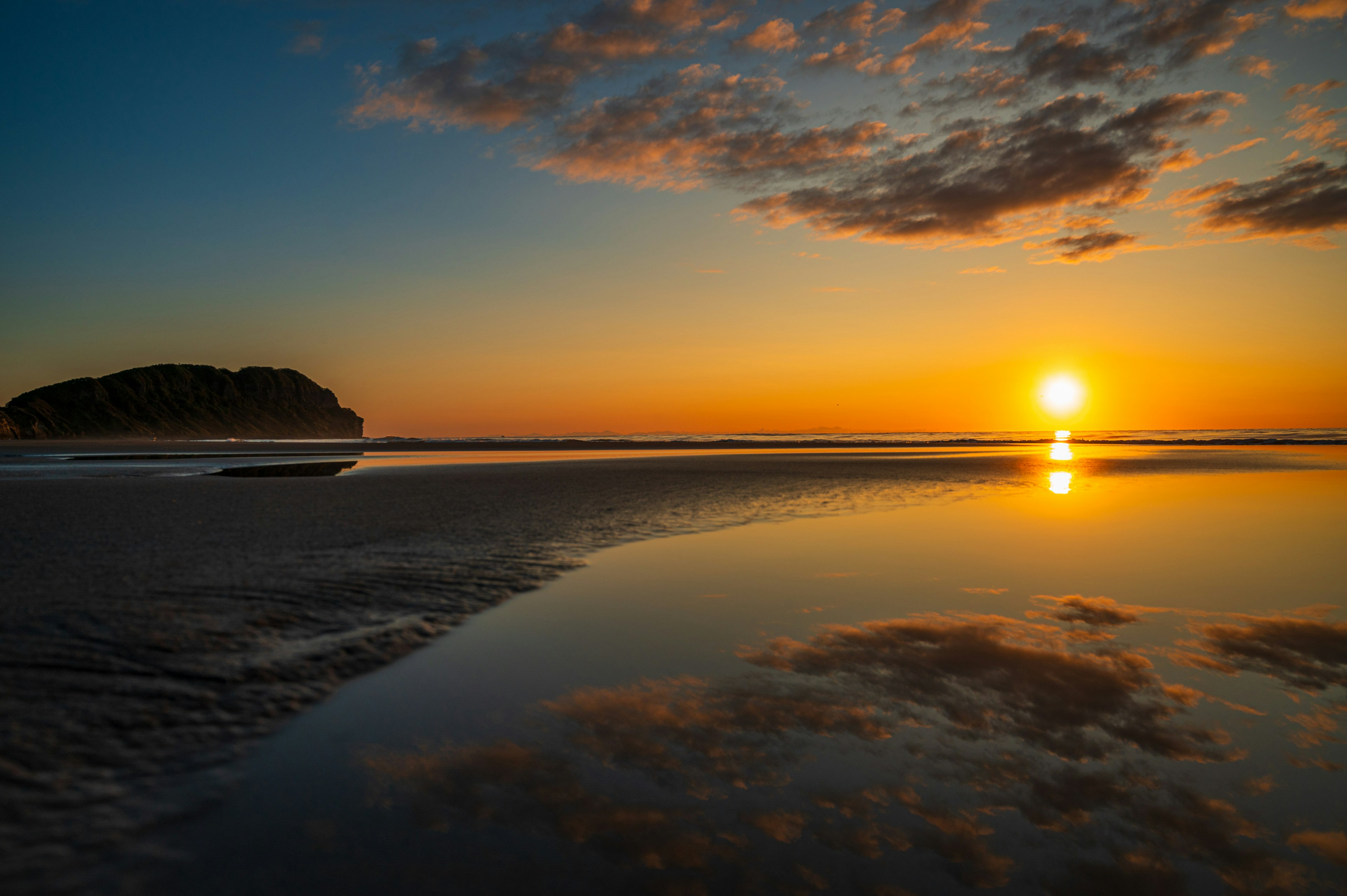 Paysage magnifique avec le coucher de soleil se reflétant sur l'eau ciel vibrant orange et bleu