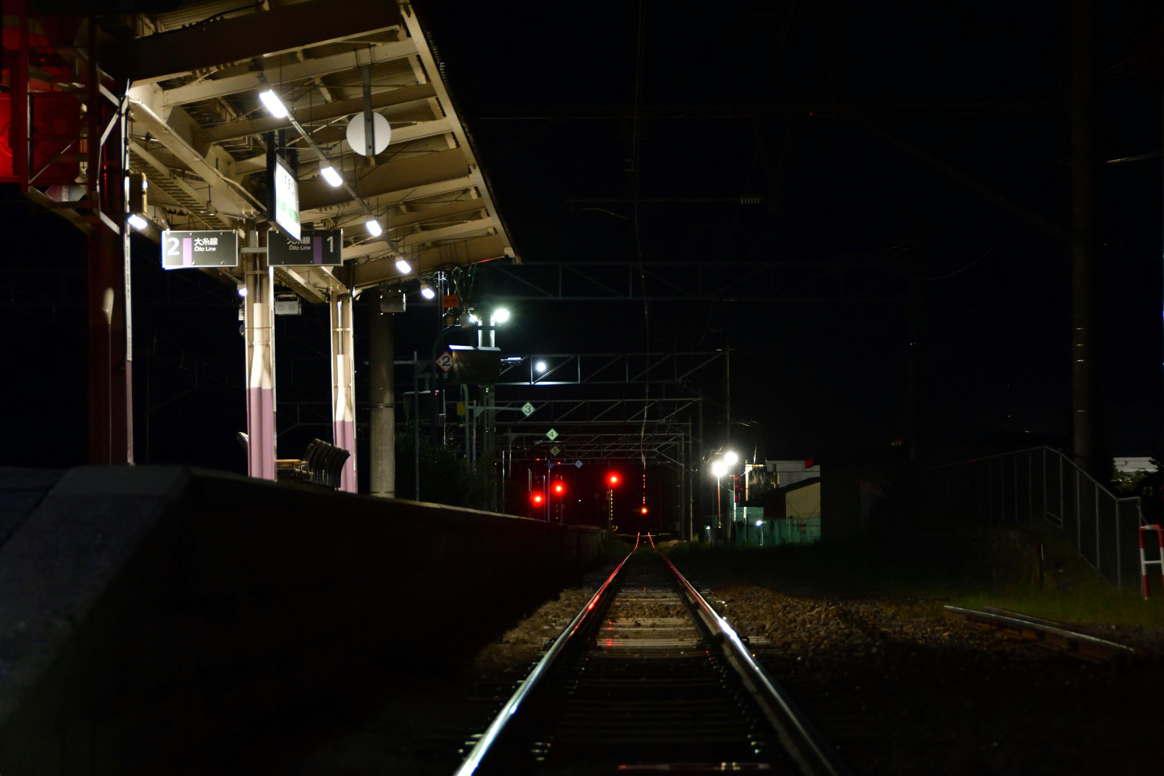 Night view of a train station platform and railway tracks