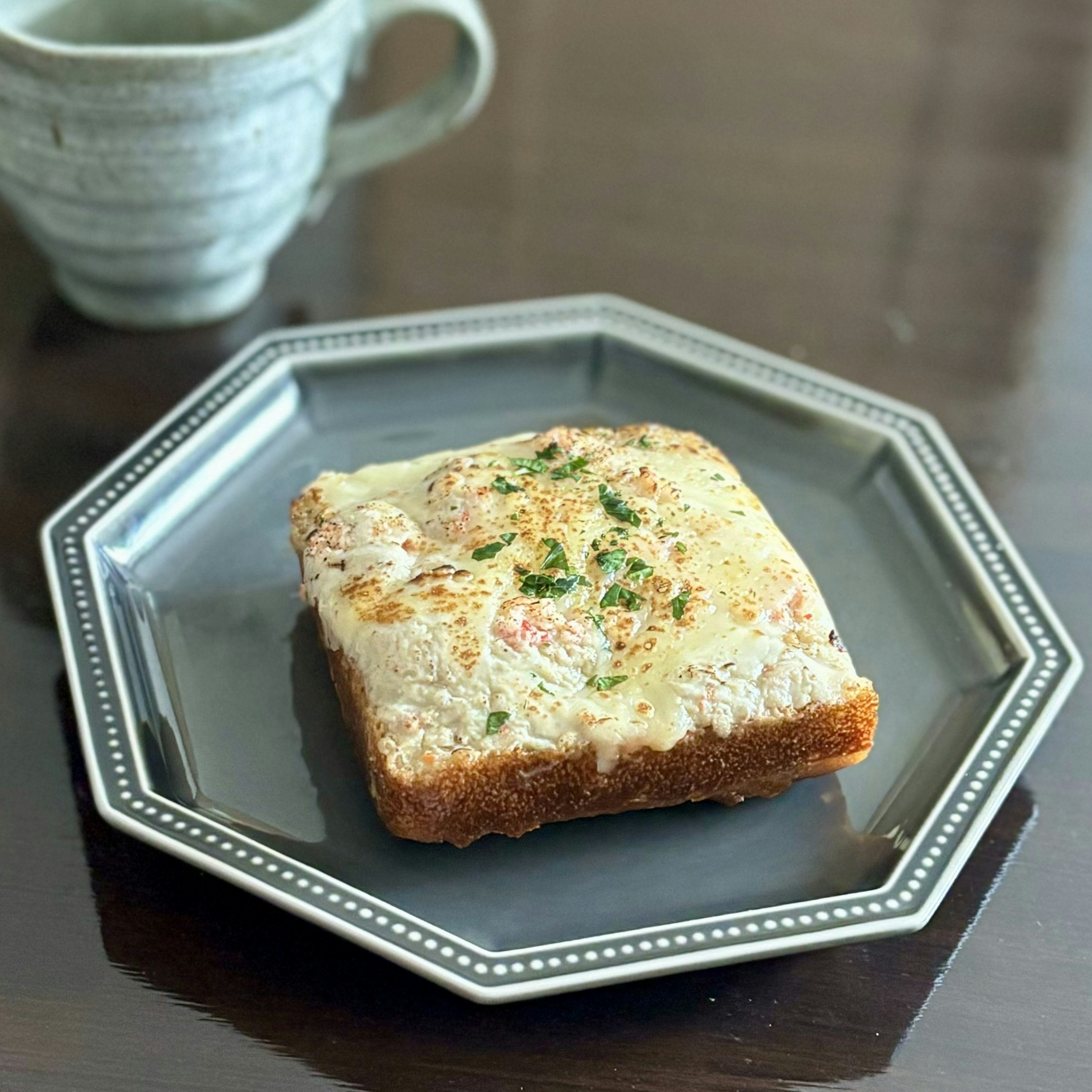 焼きパンのスライスにチーズとハーブがトッピングされた料理