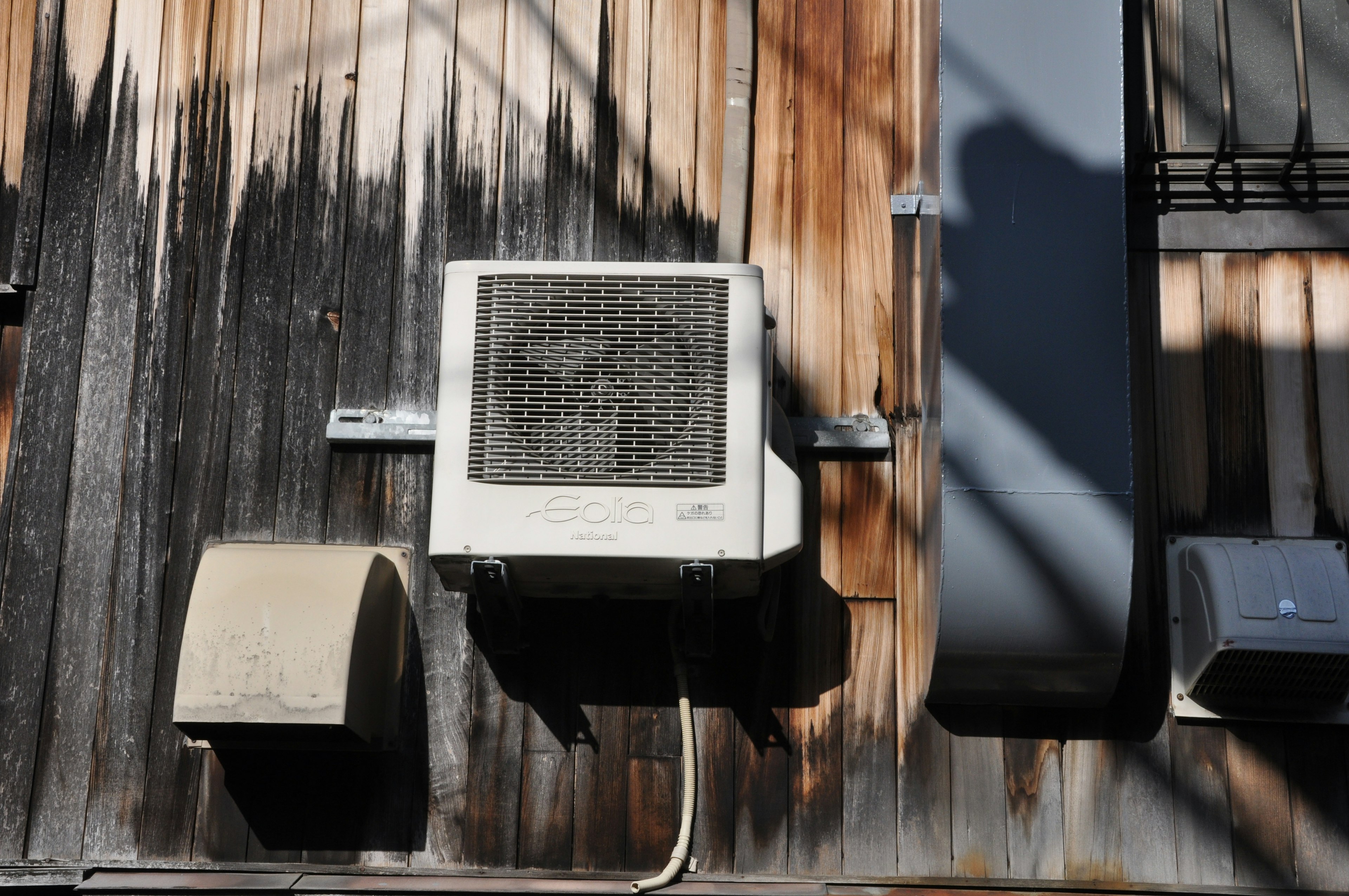 Air conditioning unit mounted on an aged wall with visible wear and textures