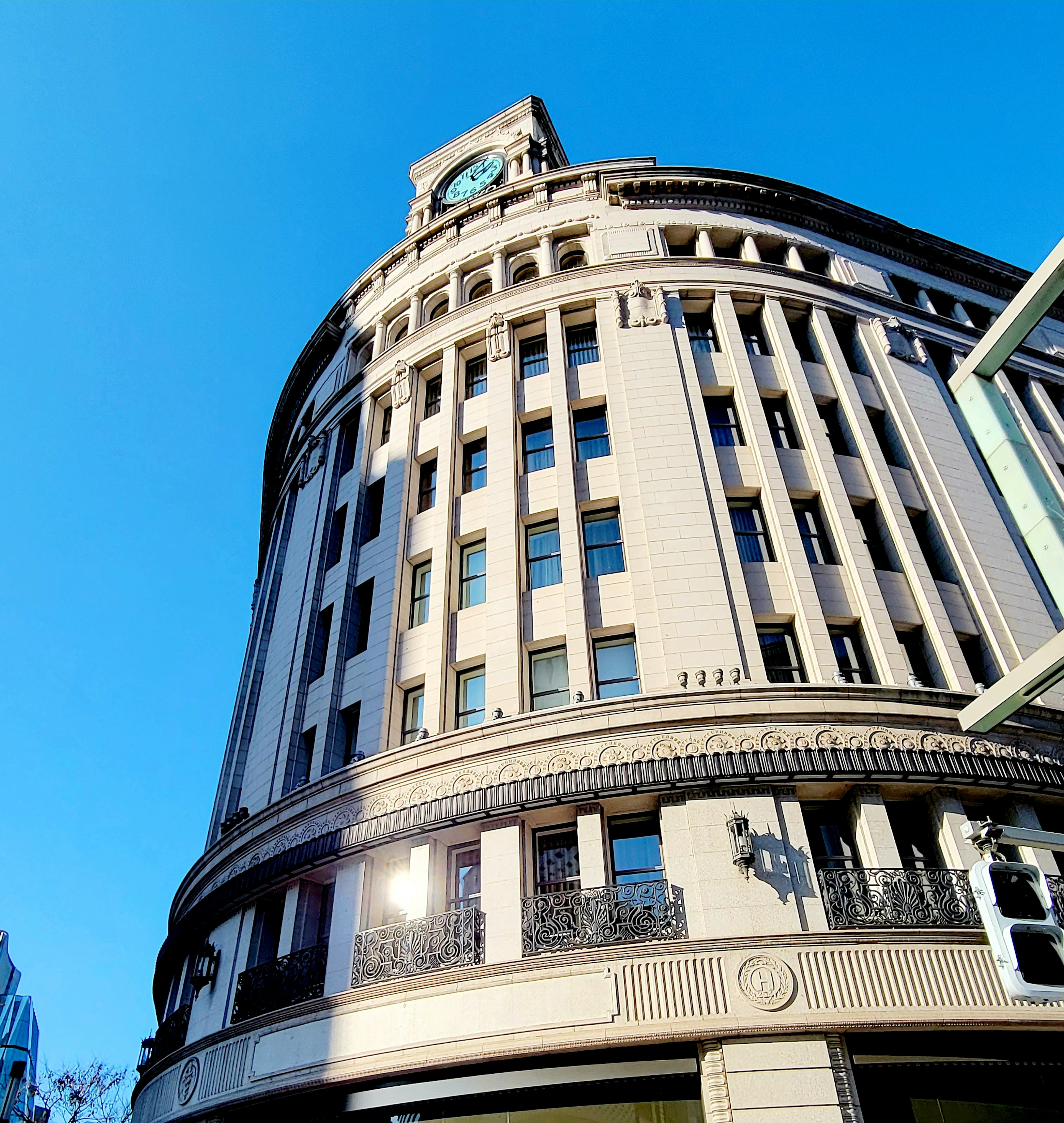 Cityscape featuring a rounded building with a clock against a blue sky