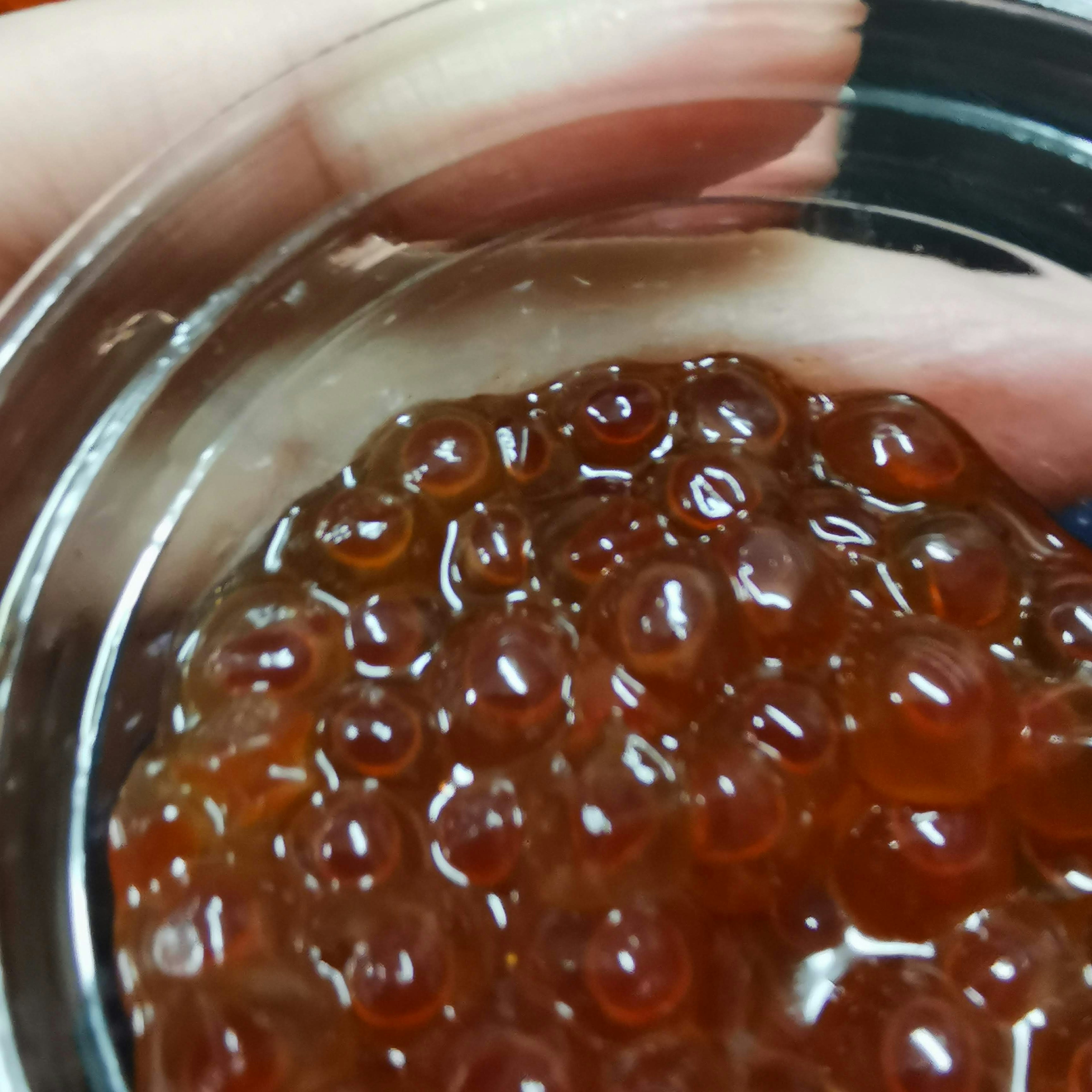 Salmon roe in a transparent container held in a hand