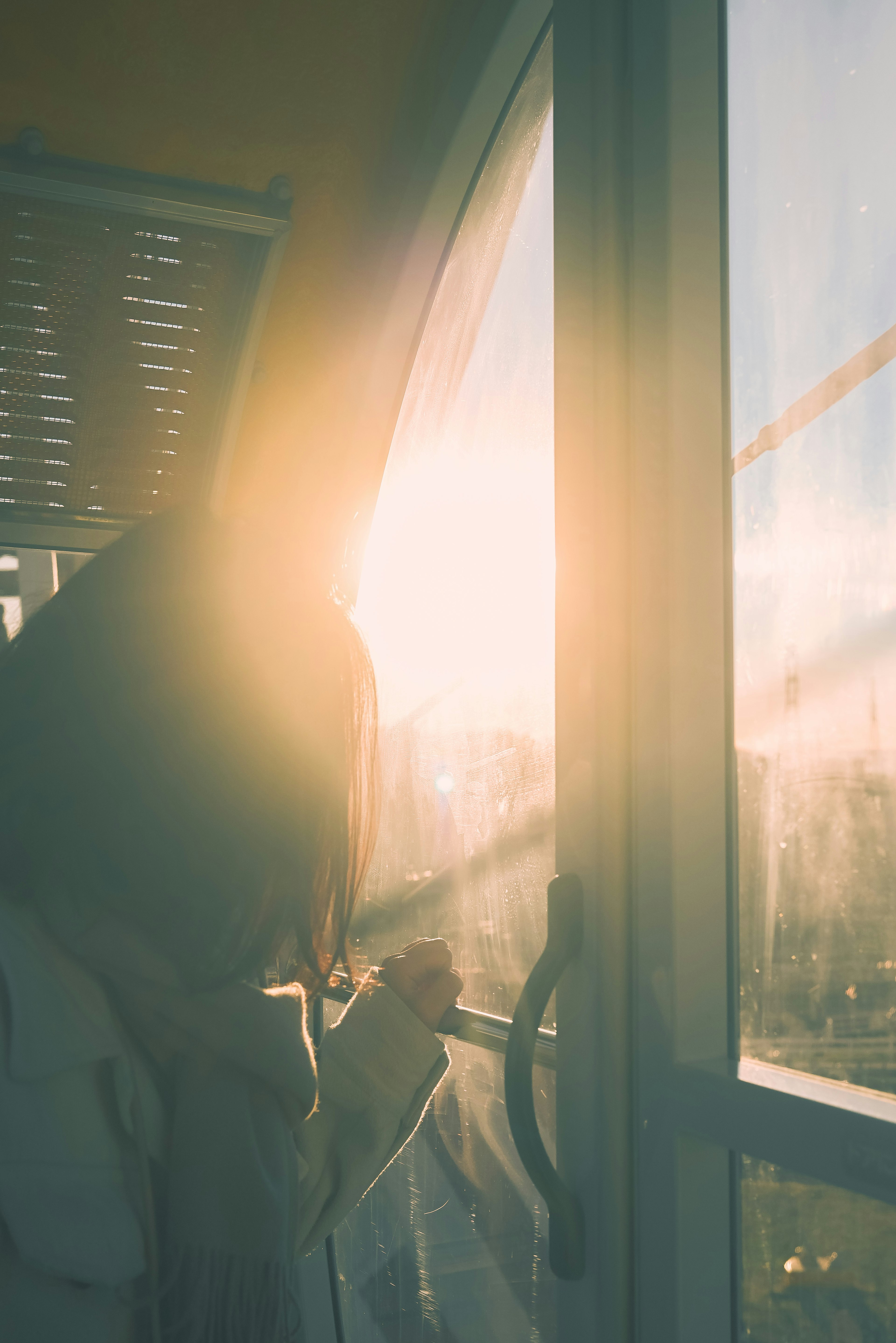 Silhouette d'une femme près d'une fenêtre baignée de lumière du soleil