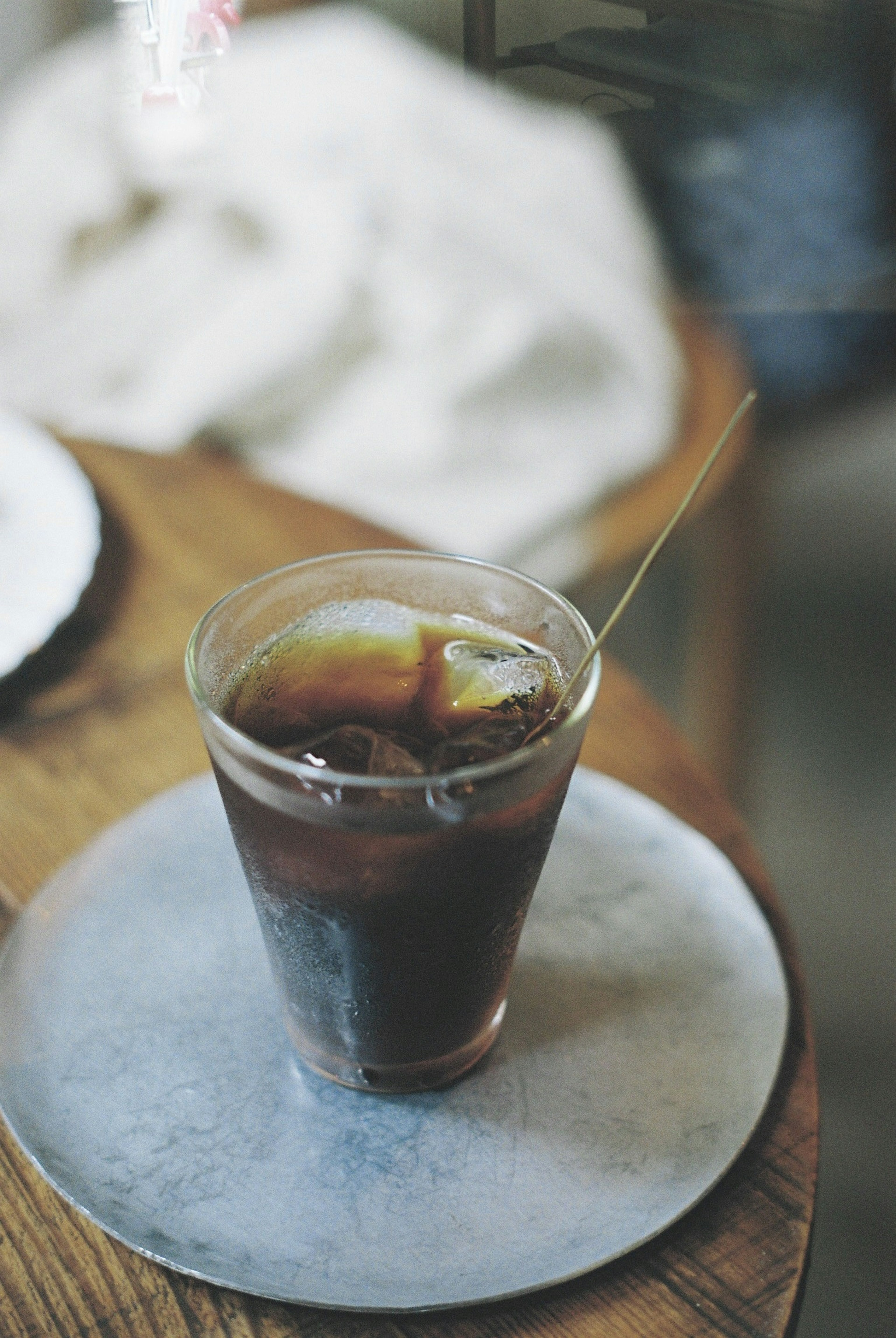 Ein Glas mit Eiskaffee und einem goldenen Löffel auf einem Holztisch