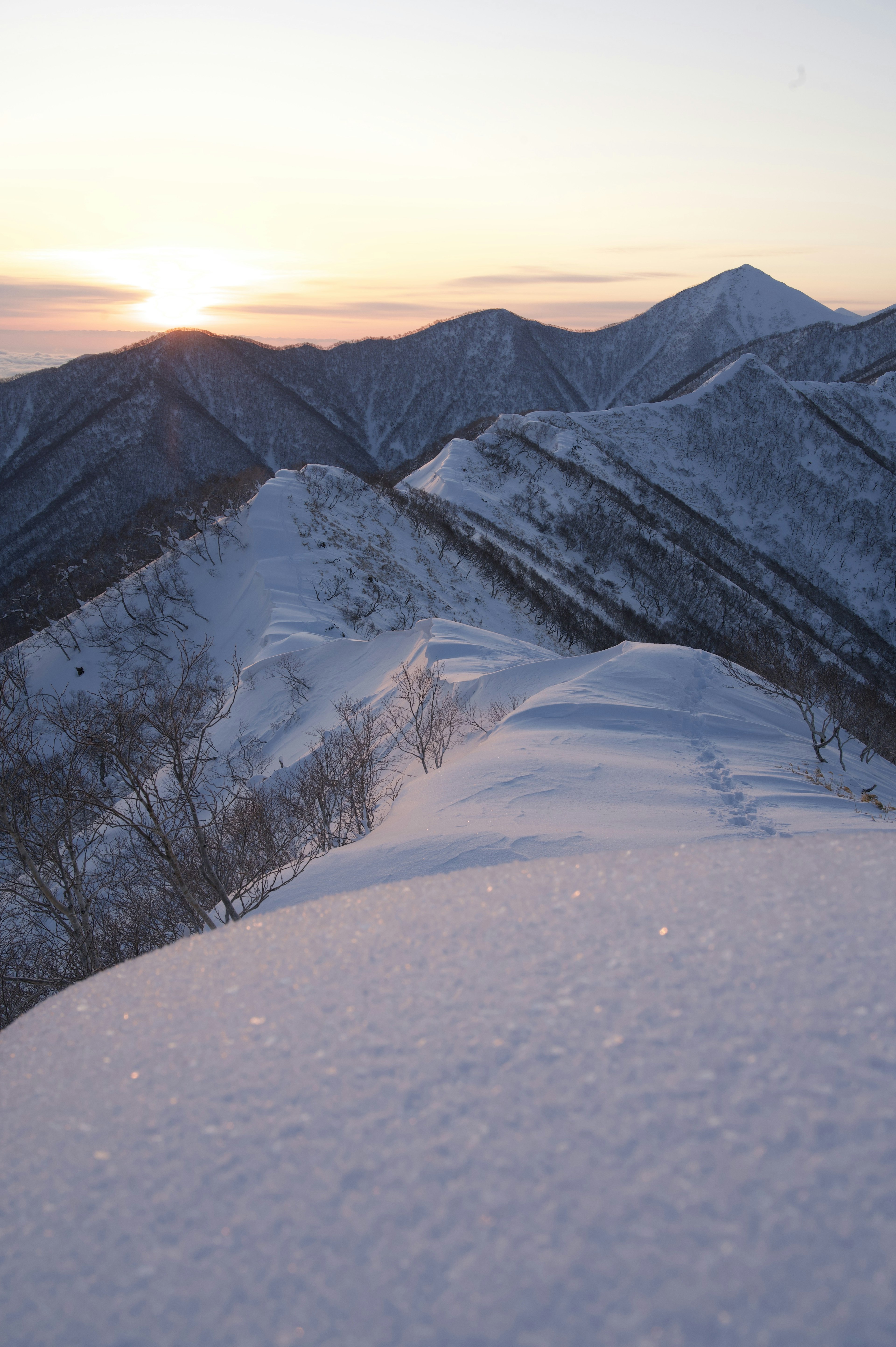 ทิวทัศน์ที่สวยงามของภูเขาที่ปกคลุมด้วยหิมะและพระอาทิตย์ตก