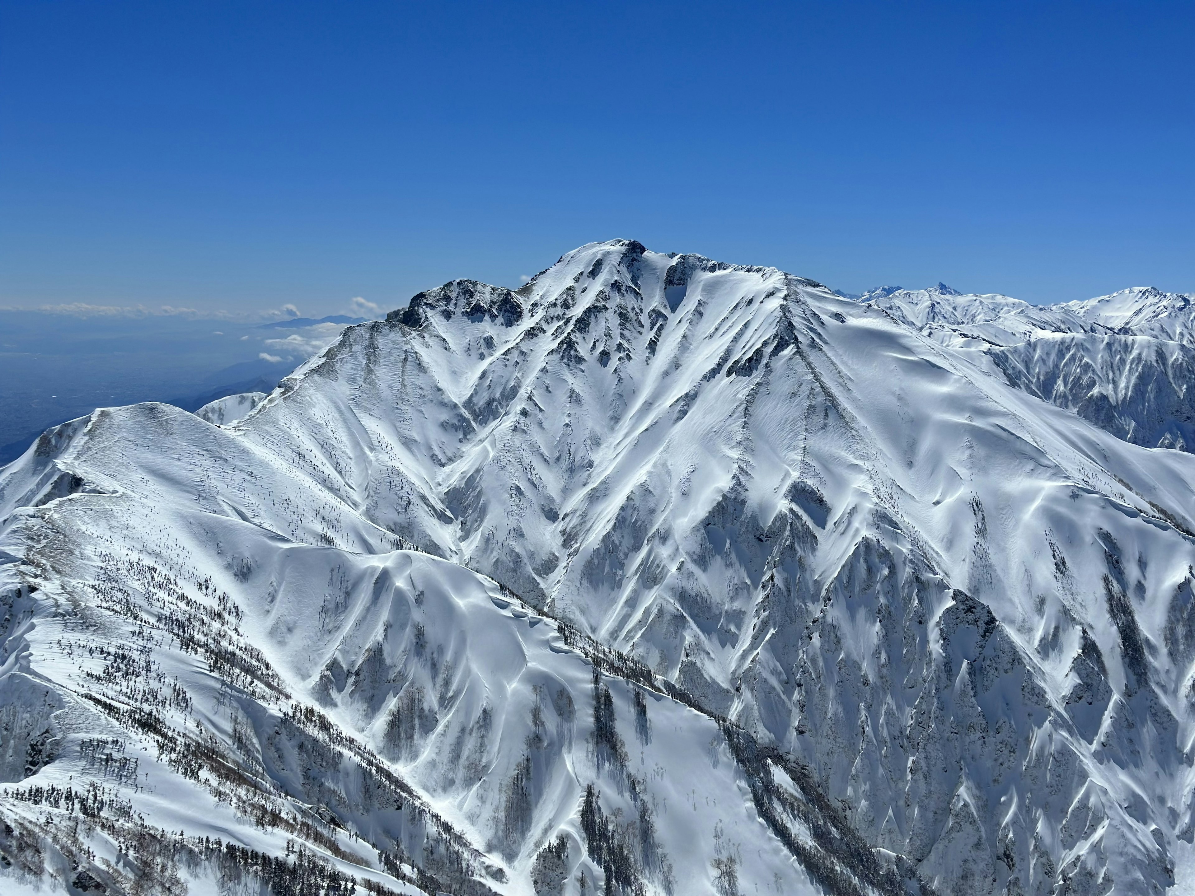 Snow-covered mountain range under a clear blue sky