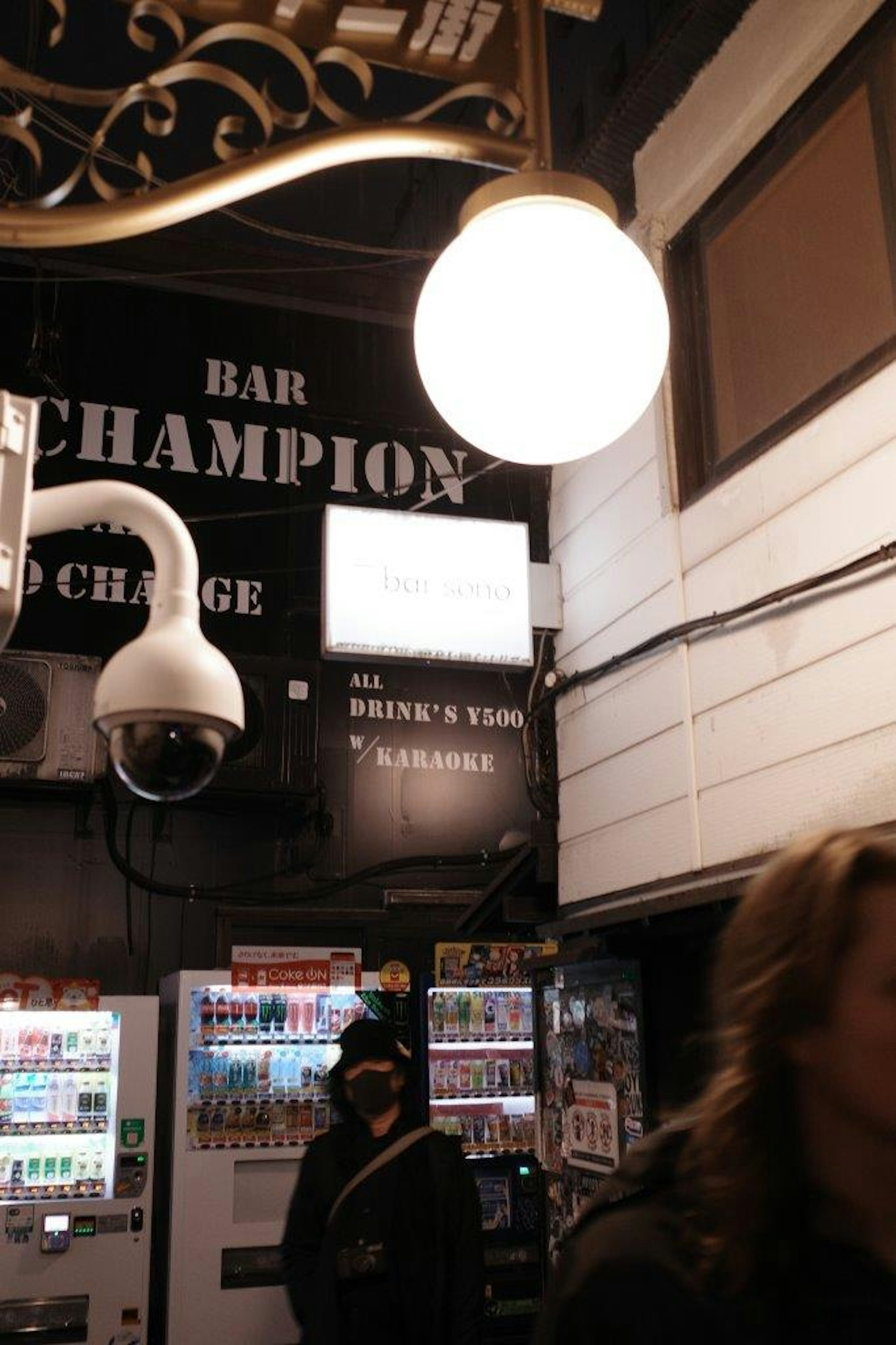 Interno di un bar con un'insegna Champion e un grande lampadario