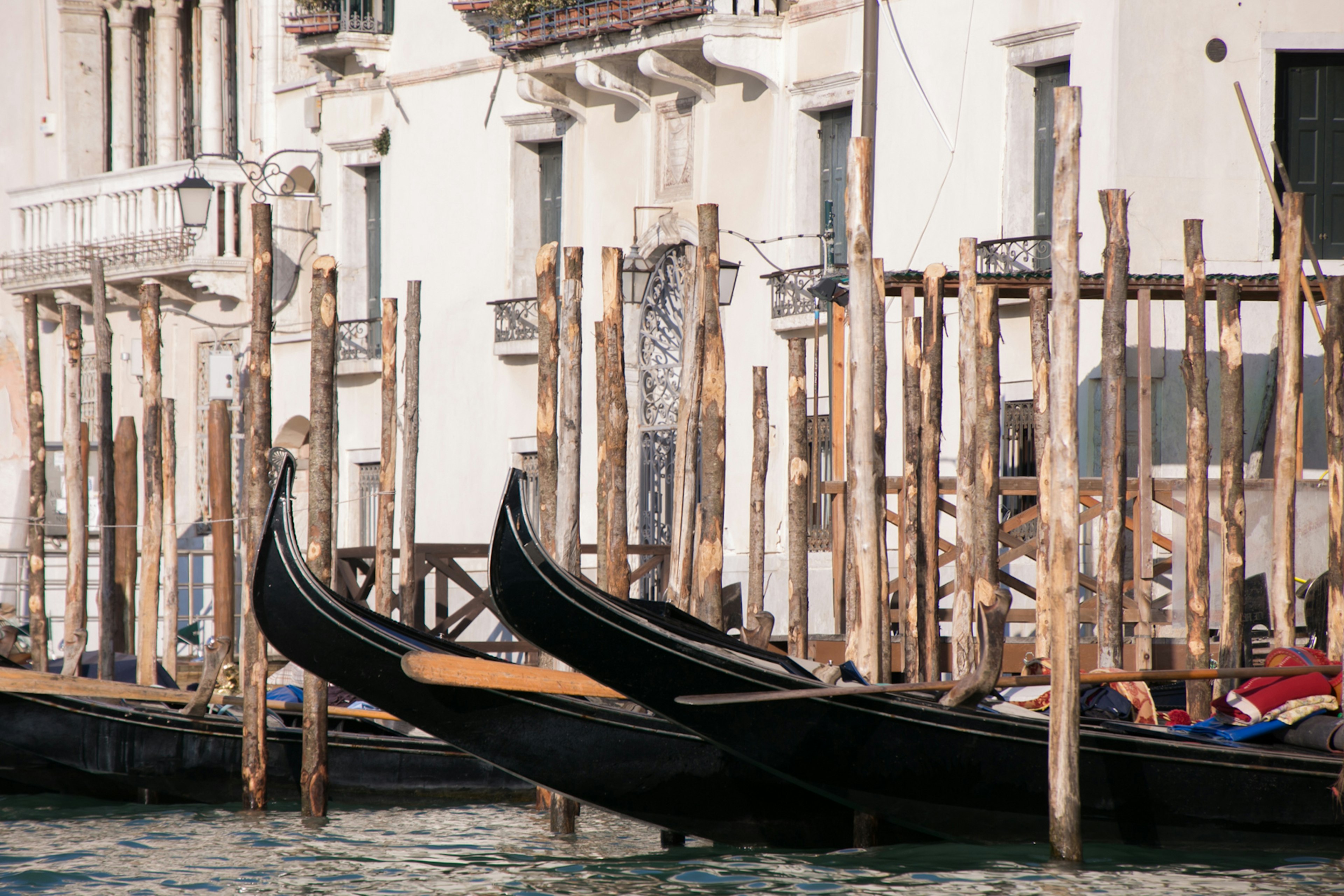 Gondolas moored at a wooden dock along a canal in Venice