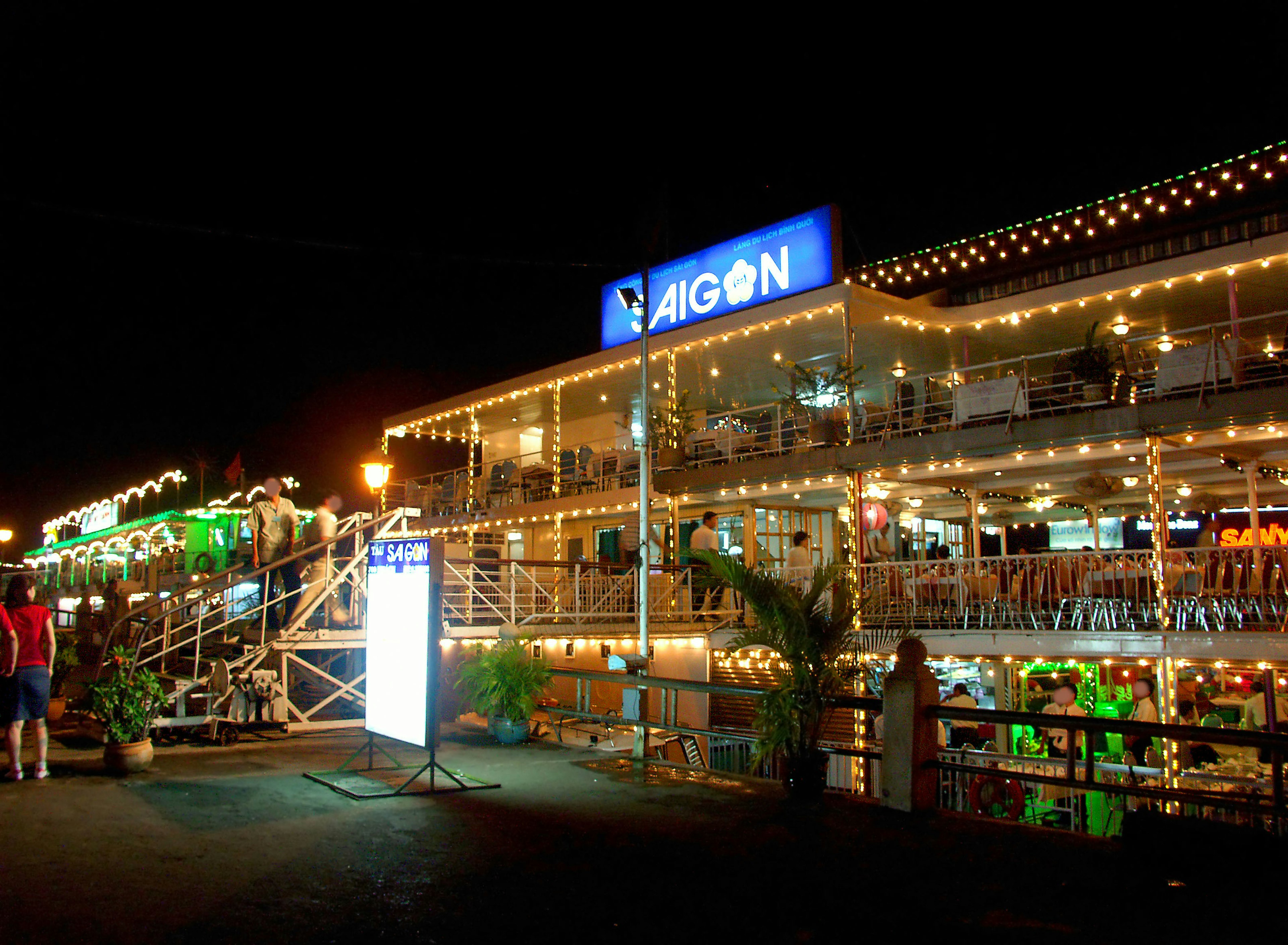 Exterior de un restaurante asiático de noche con iluminación brillante y un letrero prominente