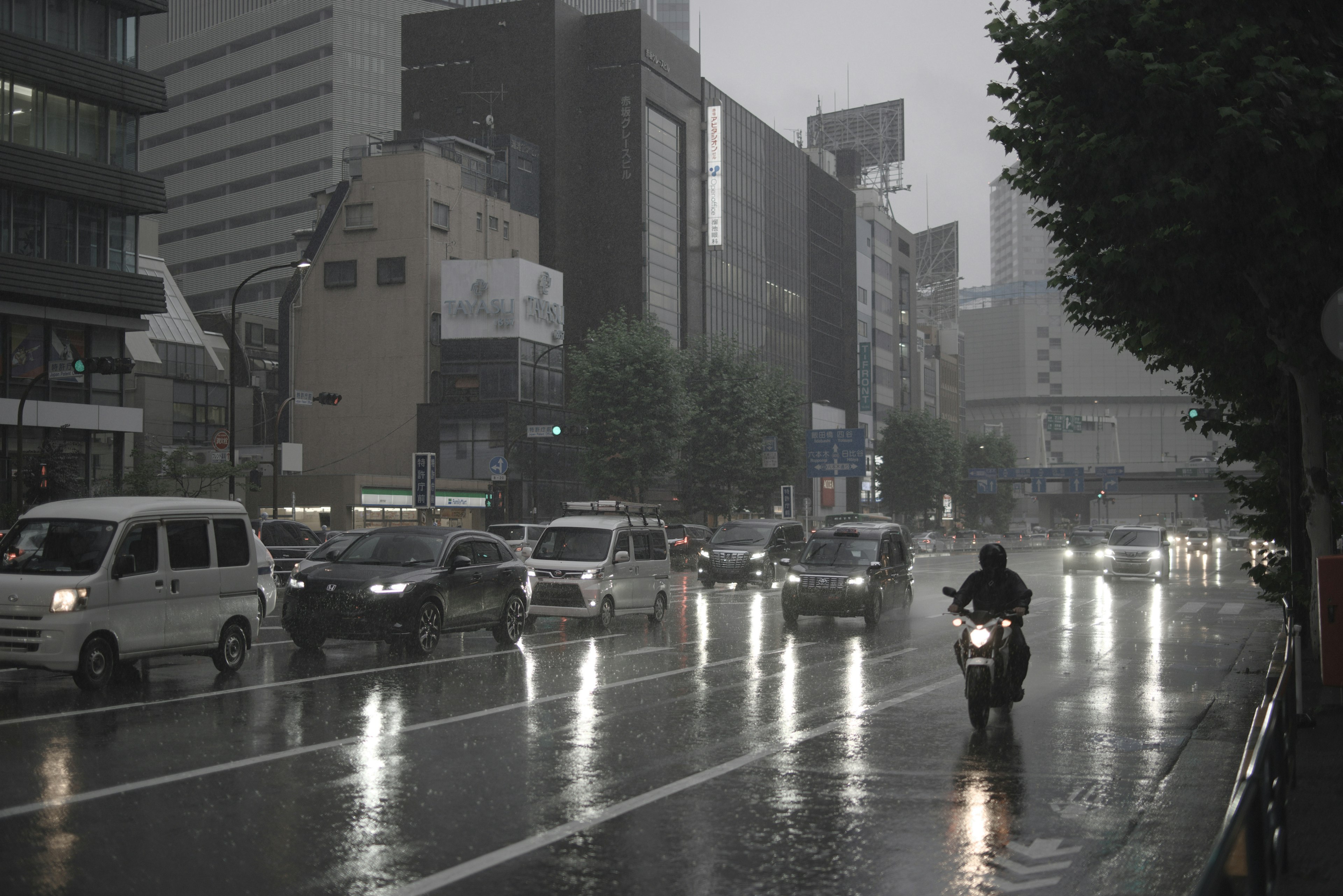 Urban scene with cars and a motorcycle in heavy rain