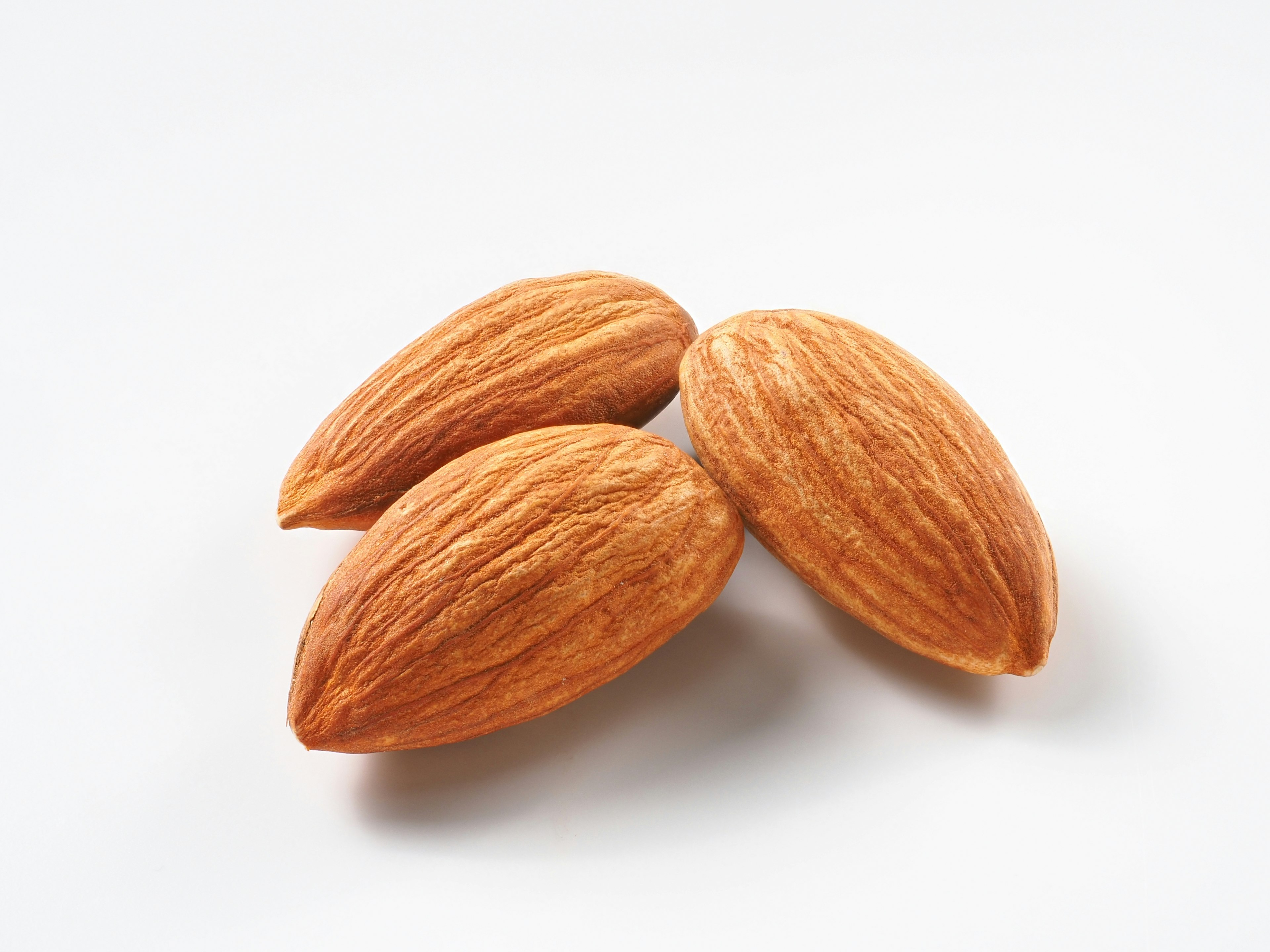 Tiga almond diletakkan di atas latar belakang putih