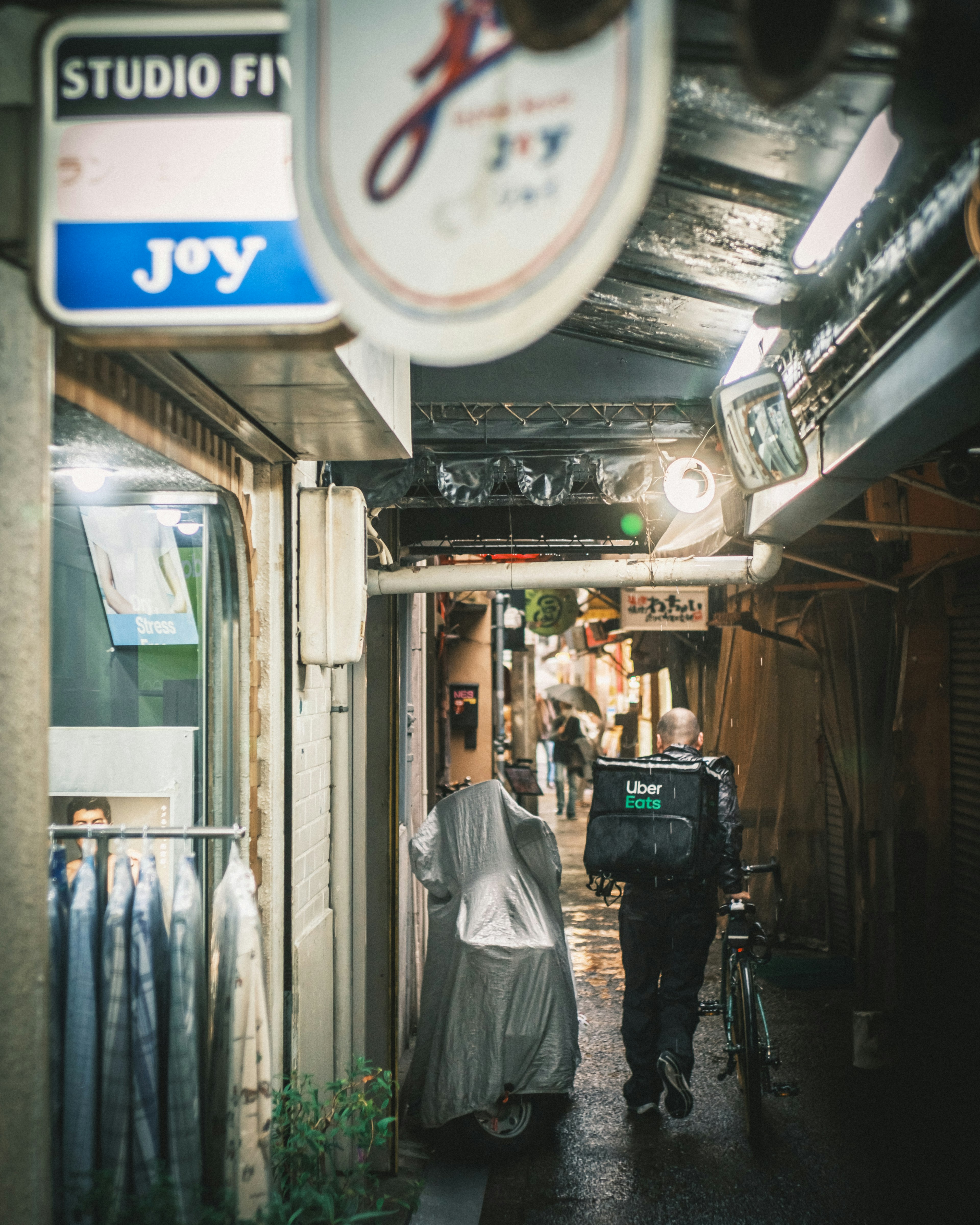 Narrow alleyway with shops and people visible at night