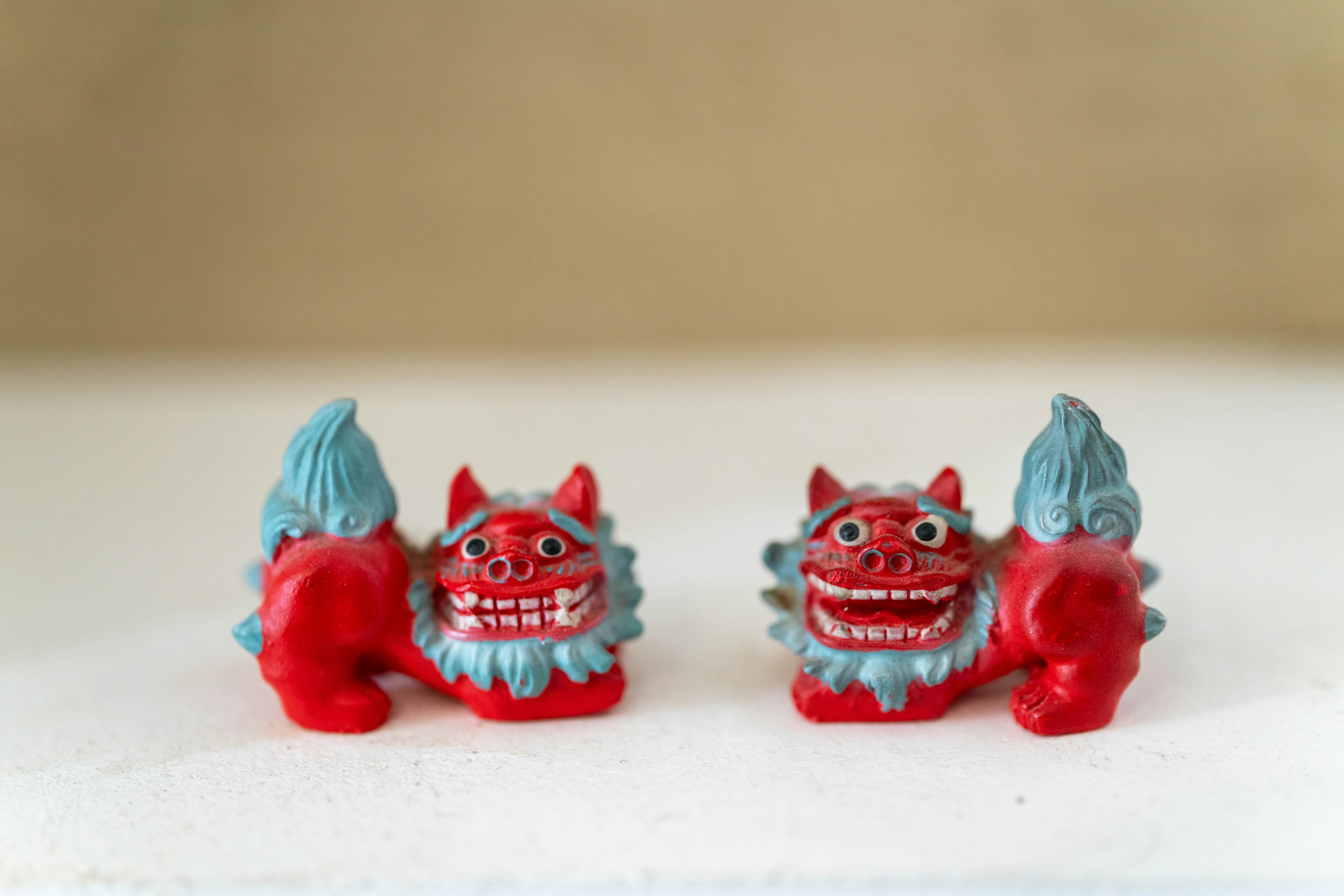 Dua patung Shisa berwarna merah dan biru