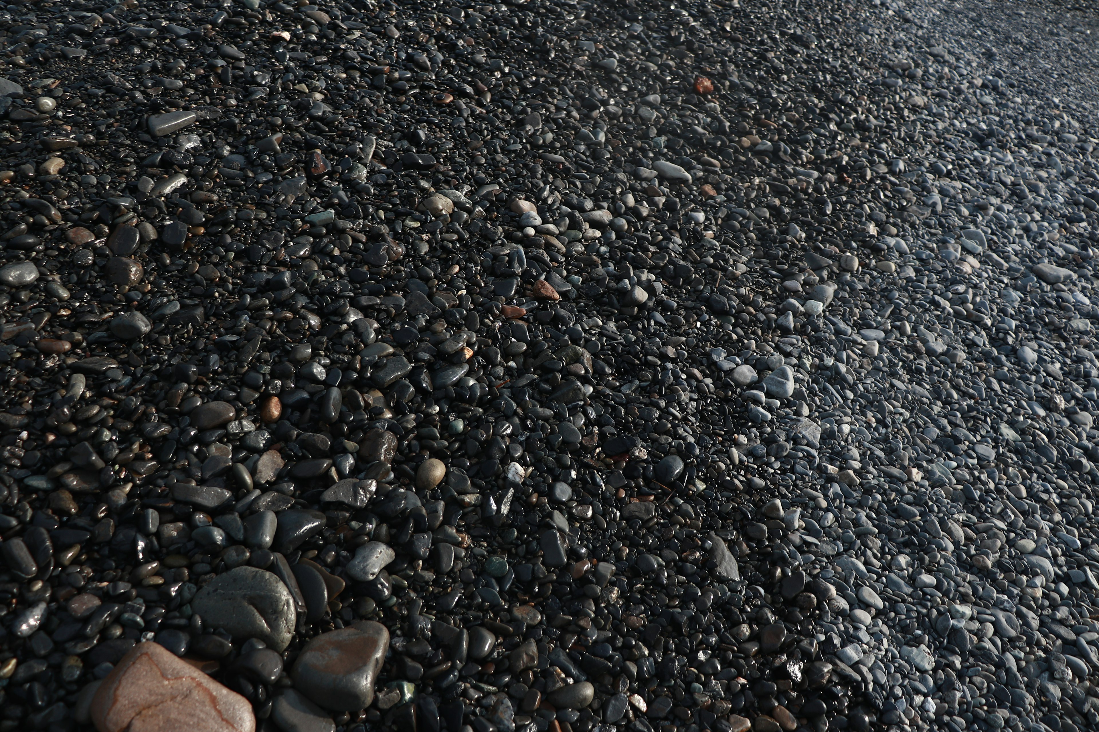 Close-up dari tanah yang ditutupi kerikil hitam