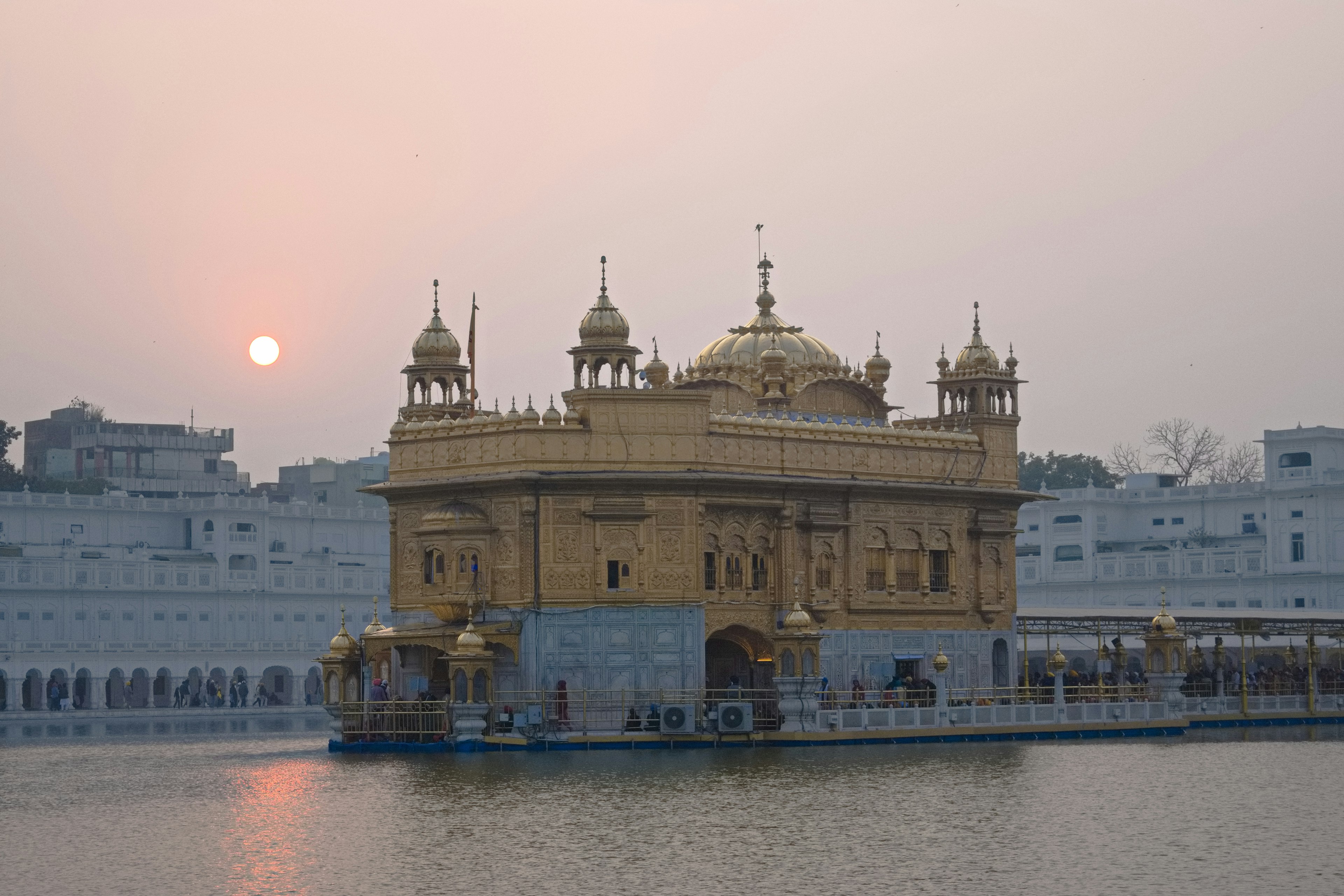 Golden temple reflecting in calm waters during sunset