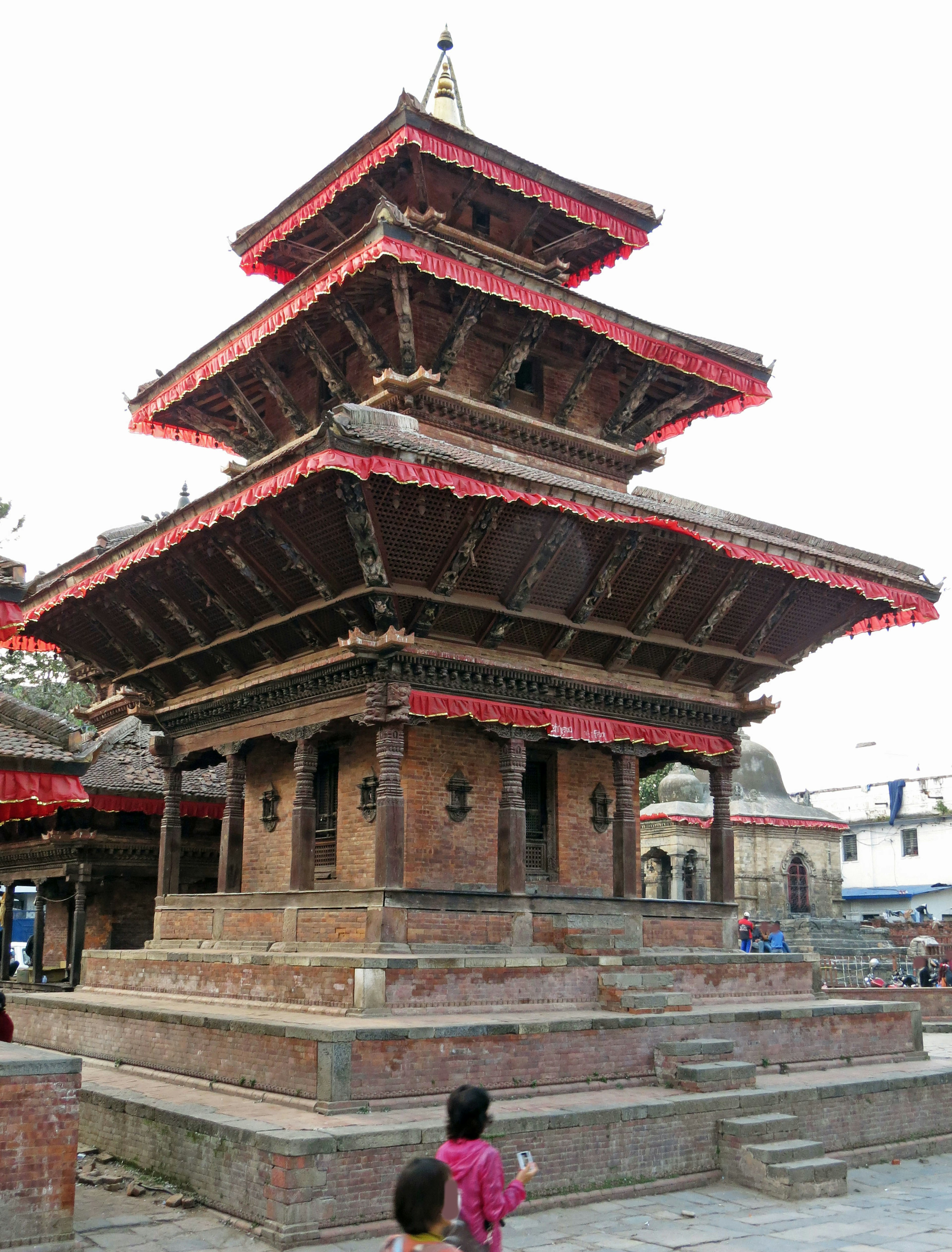 Tempio tradizionale a tre livelli in Nepal con un bambino davanti