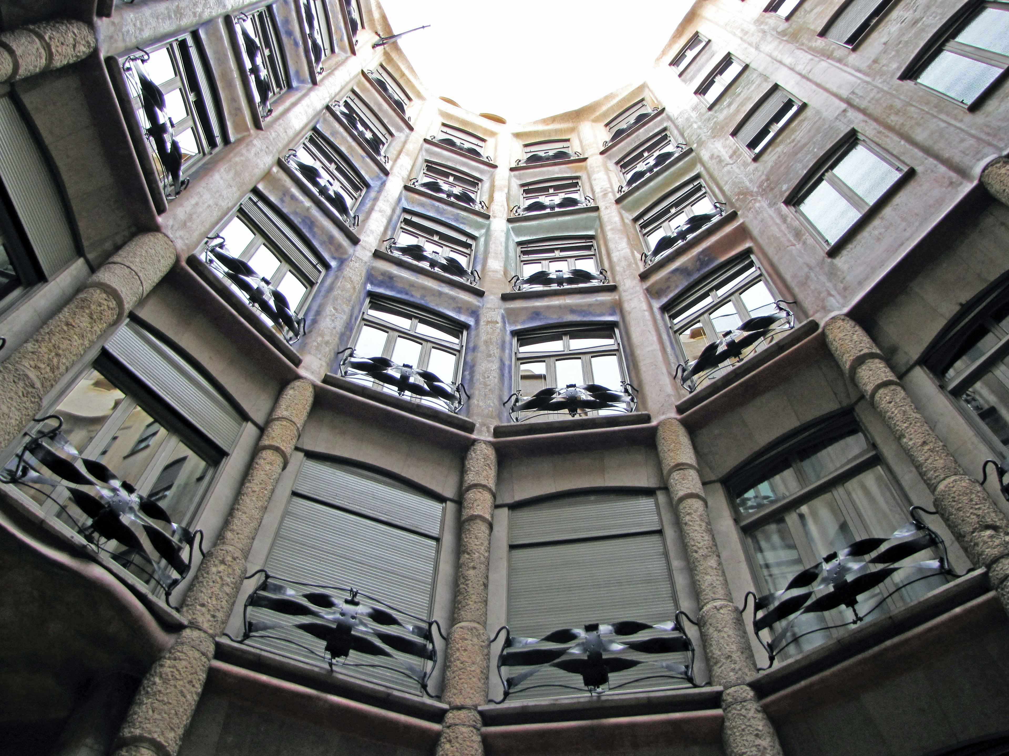 Vista desde el interior de Casa Milà mirando hacia arriba Estructura circular con ventanas y columnas decorativas