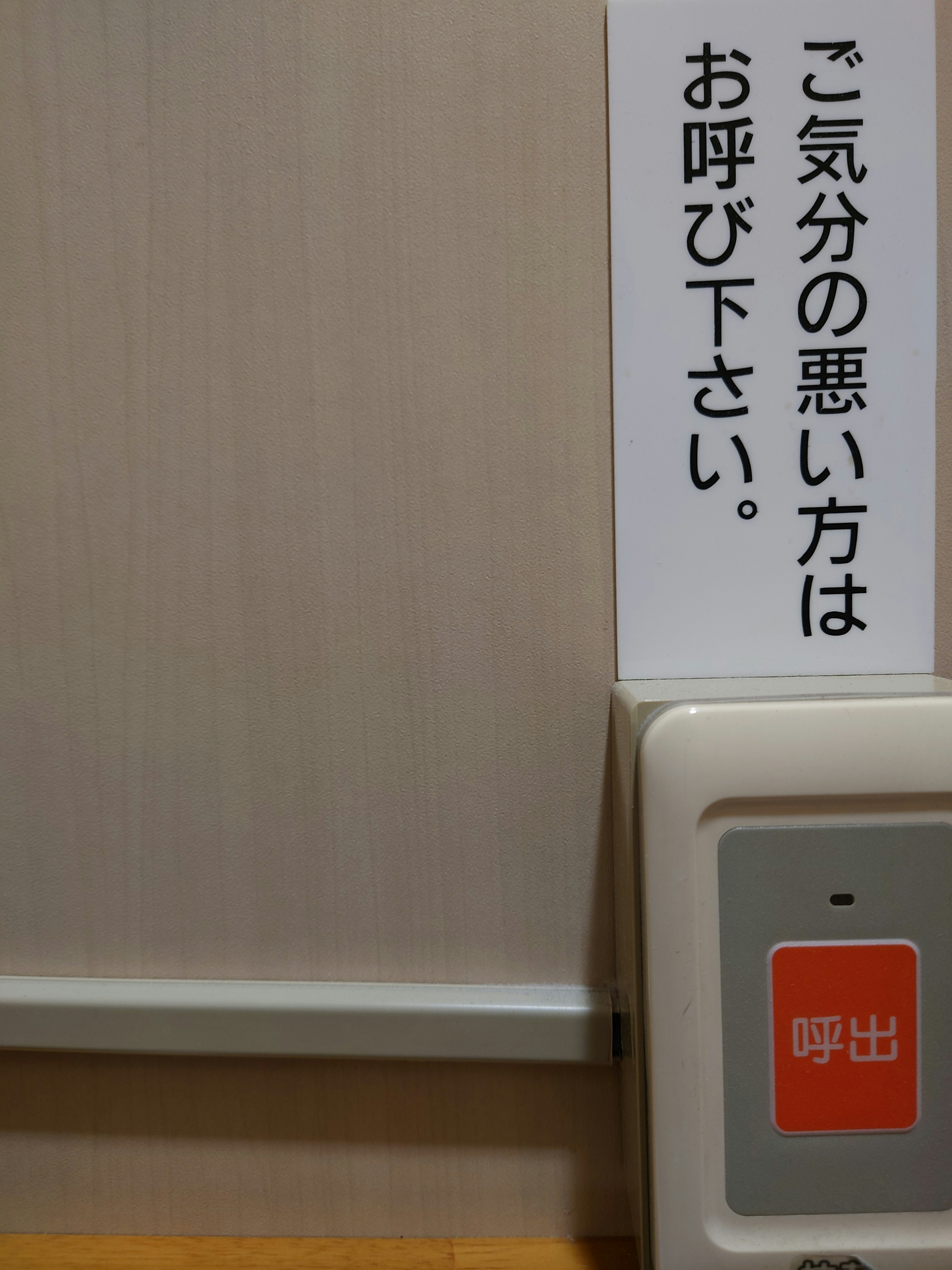 Sign indicating to call if feeling unwell with a red button