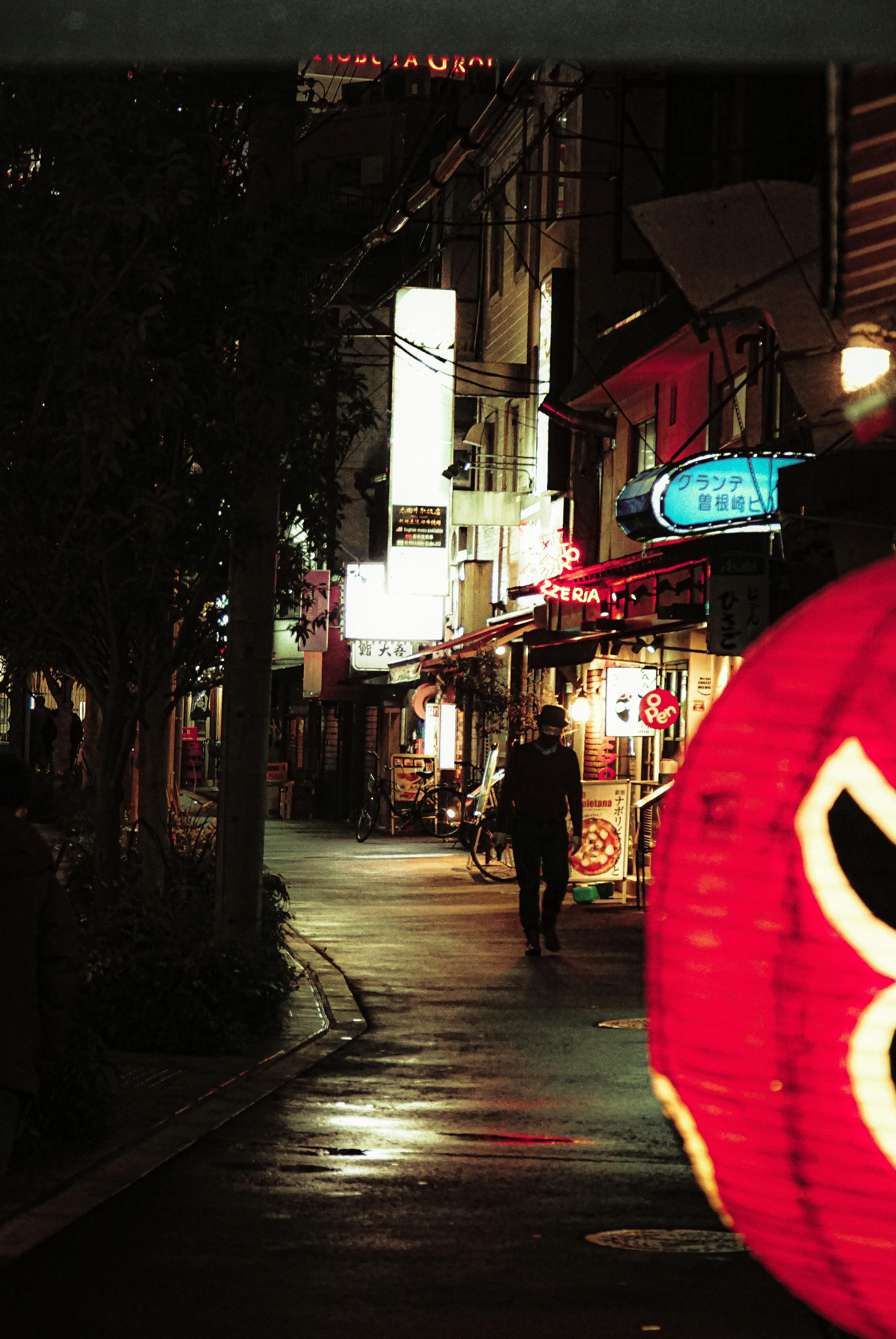 Escena nocturna de calle con una linterna roja brillante