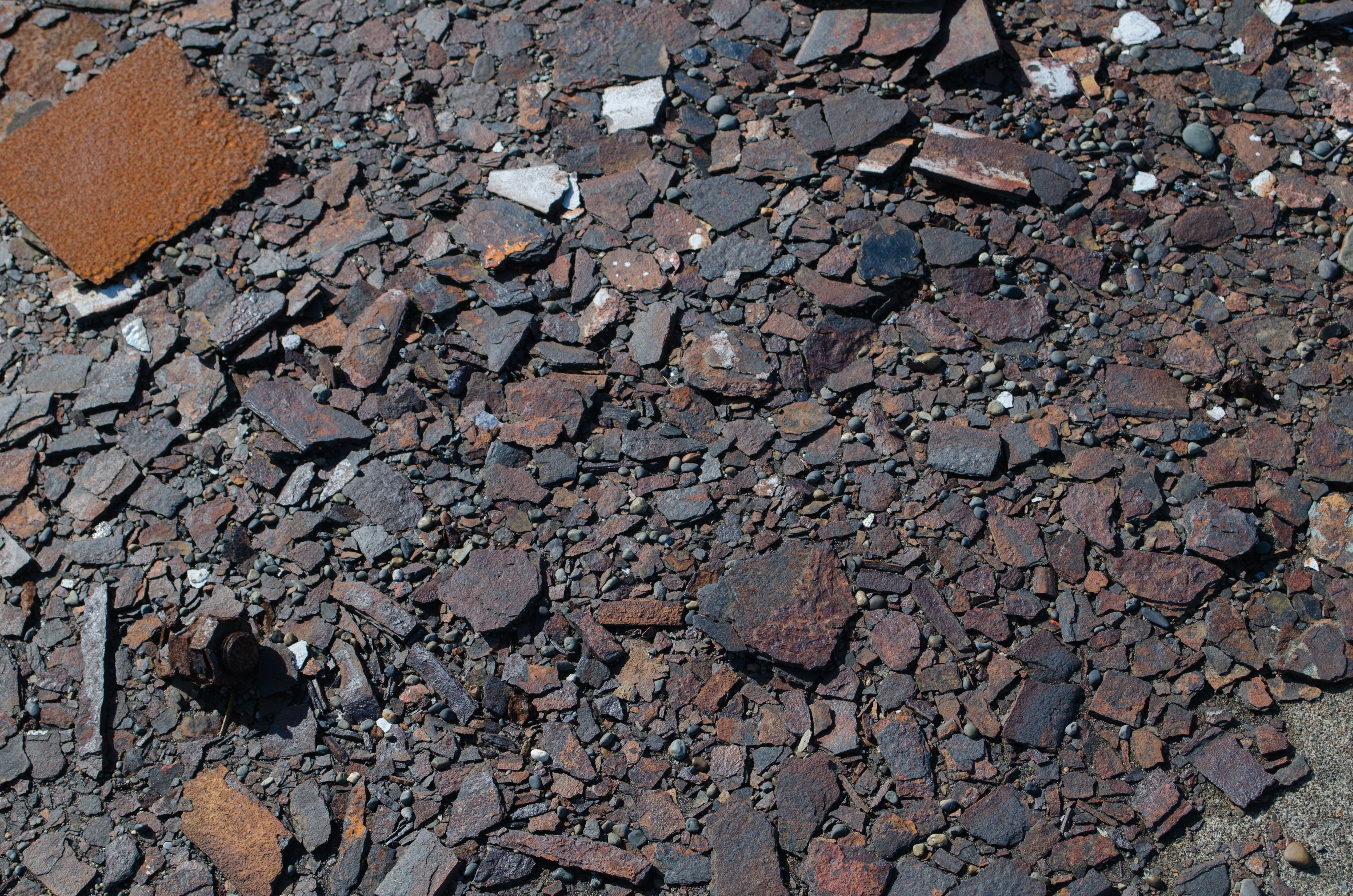 Ground covered with dark-colored rocks and gravel