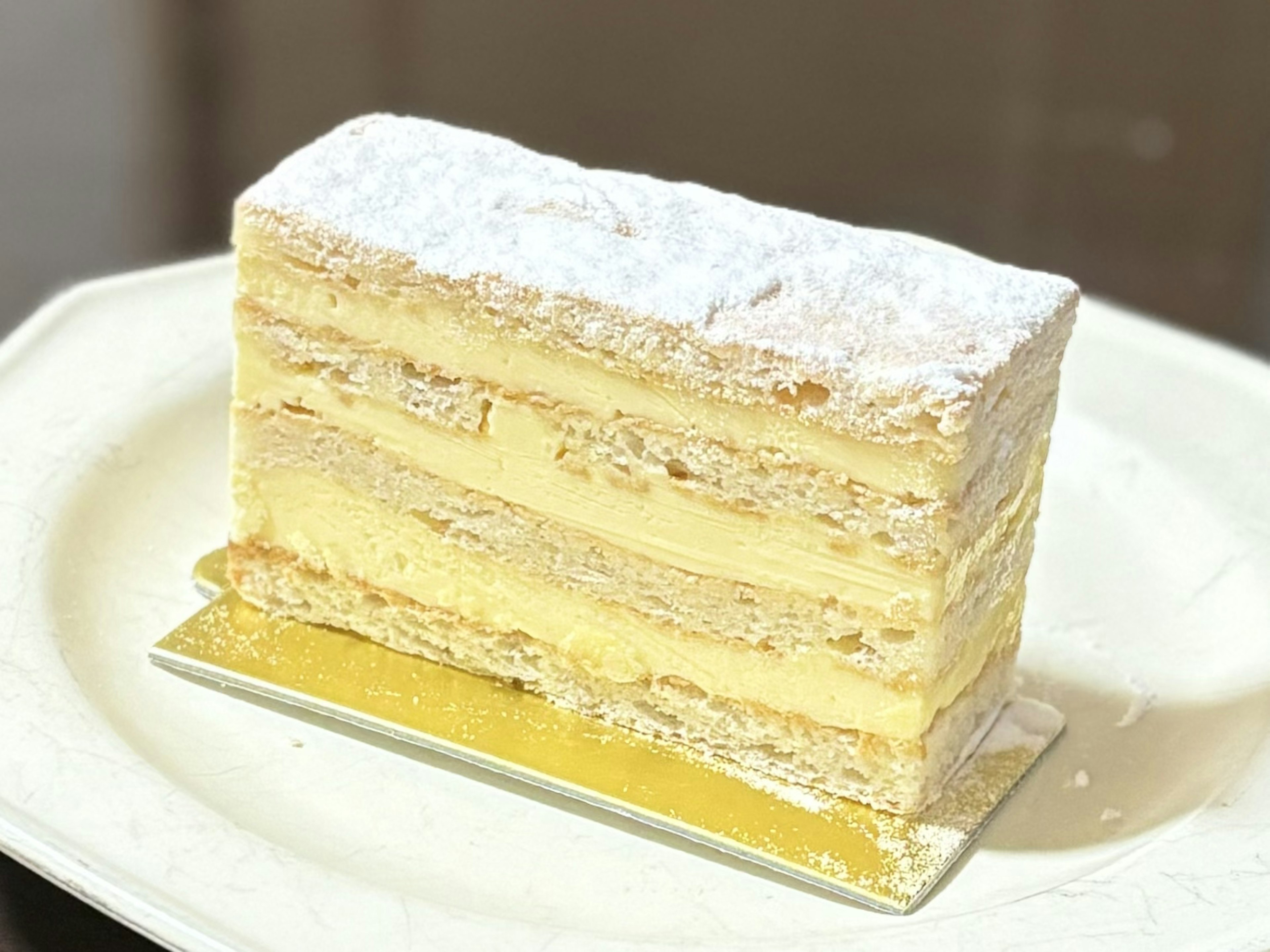 クリーム層のあるデザートケーキが白い粉砂糖で覆われた美味しそうな一品