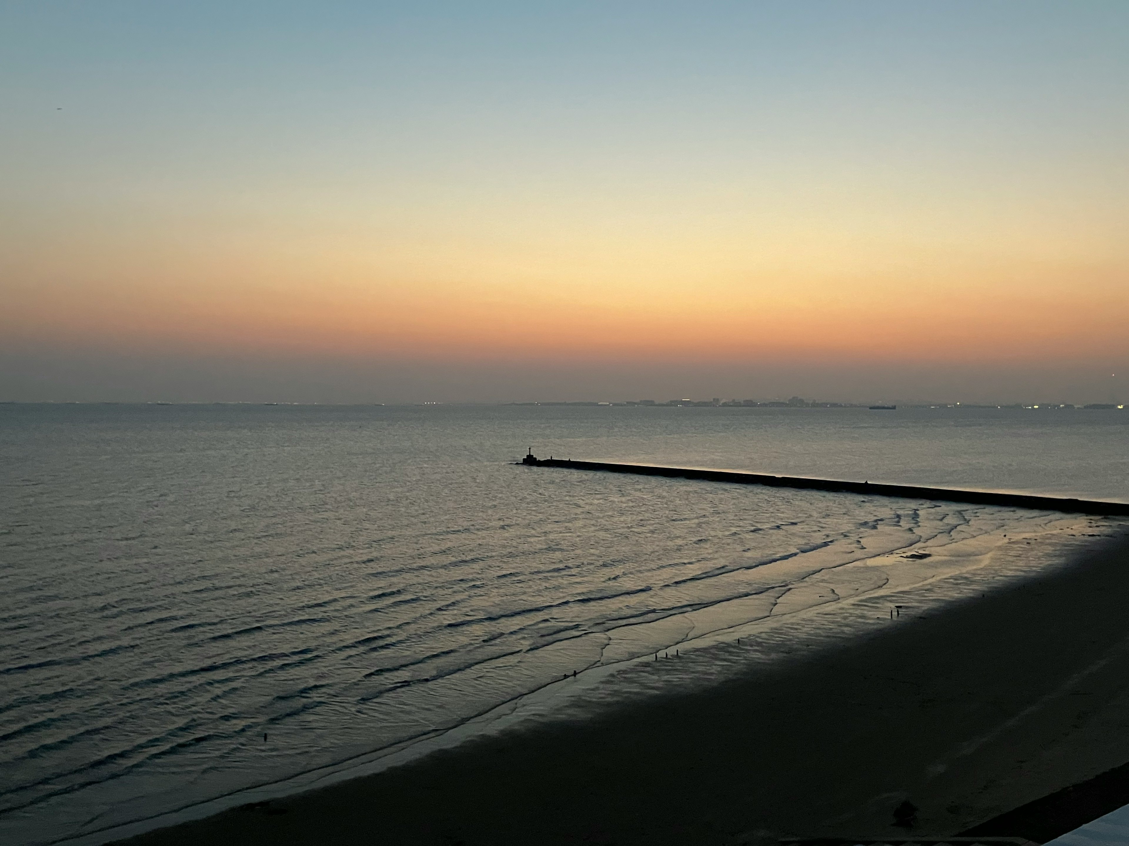 穏やかな海と夕焼けの色合いが映る風景