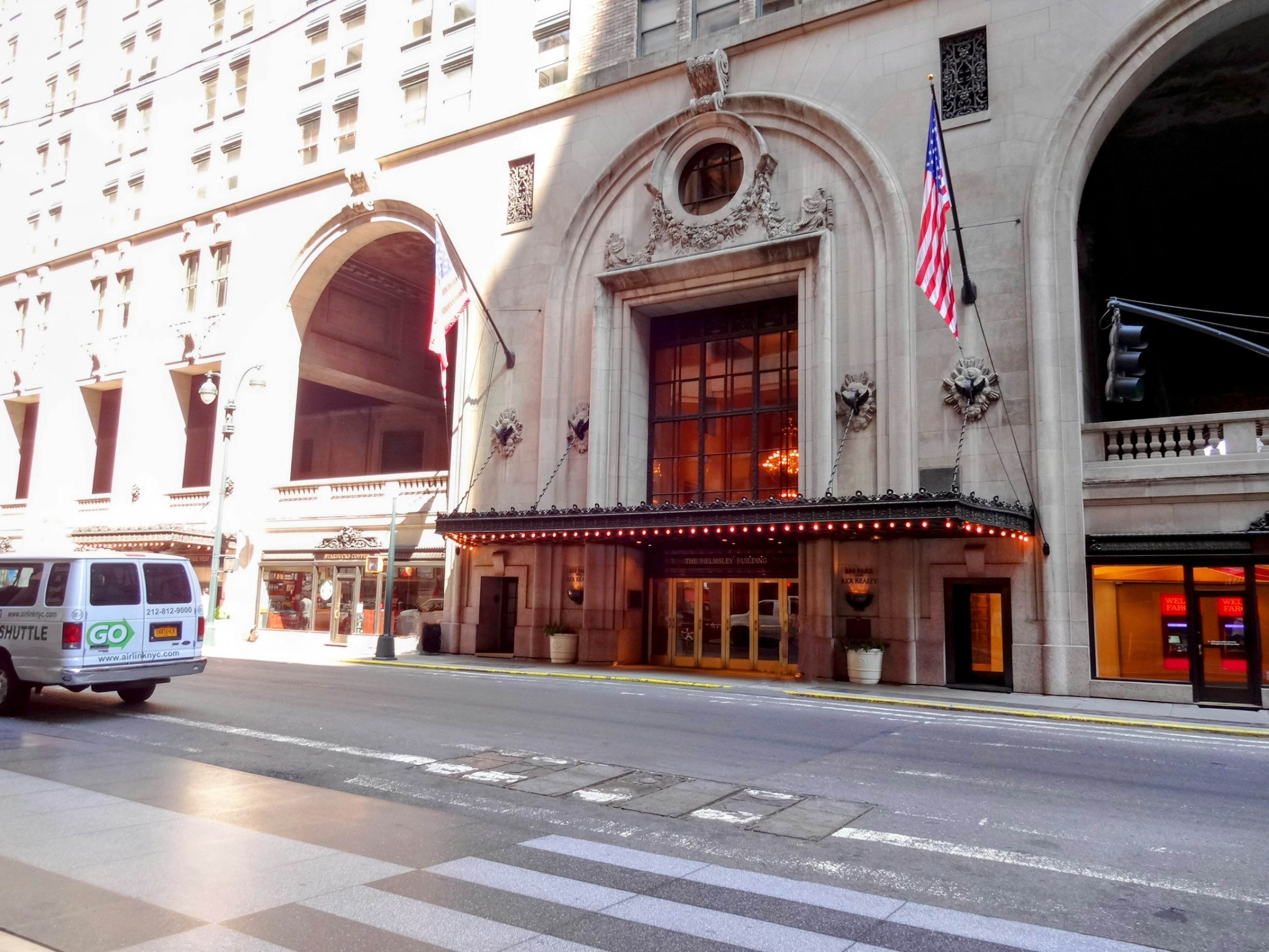 Historic hotel entrance in New York featuring an American flag and ornate architecture