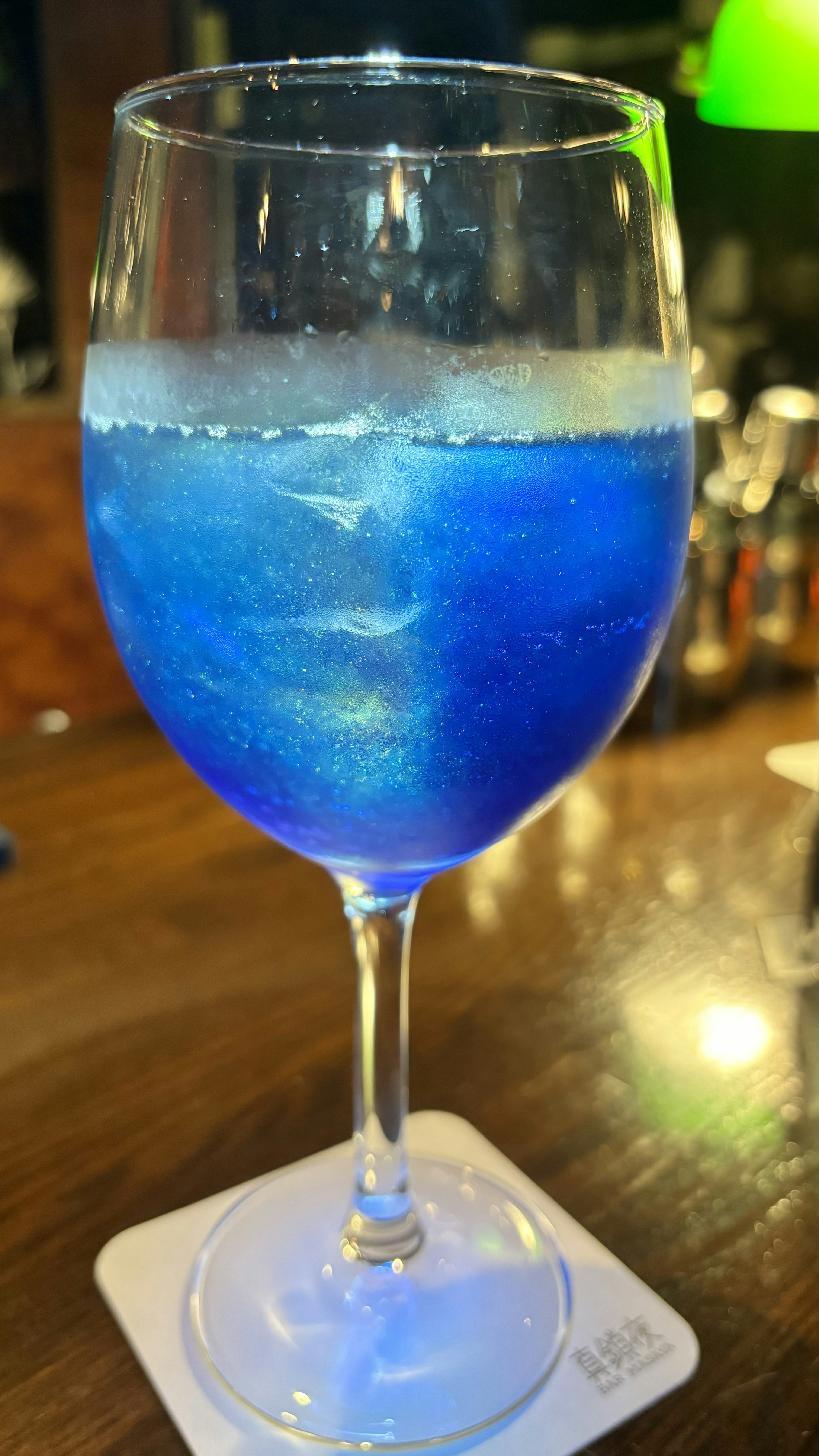 Ein blauer Cocktail in einem Glas mit glitzernden Effekten