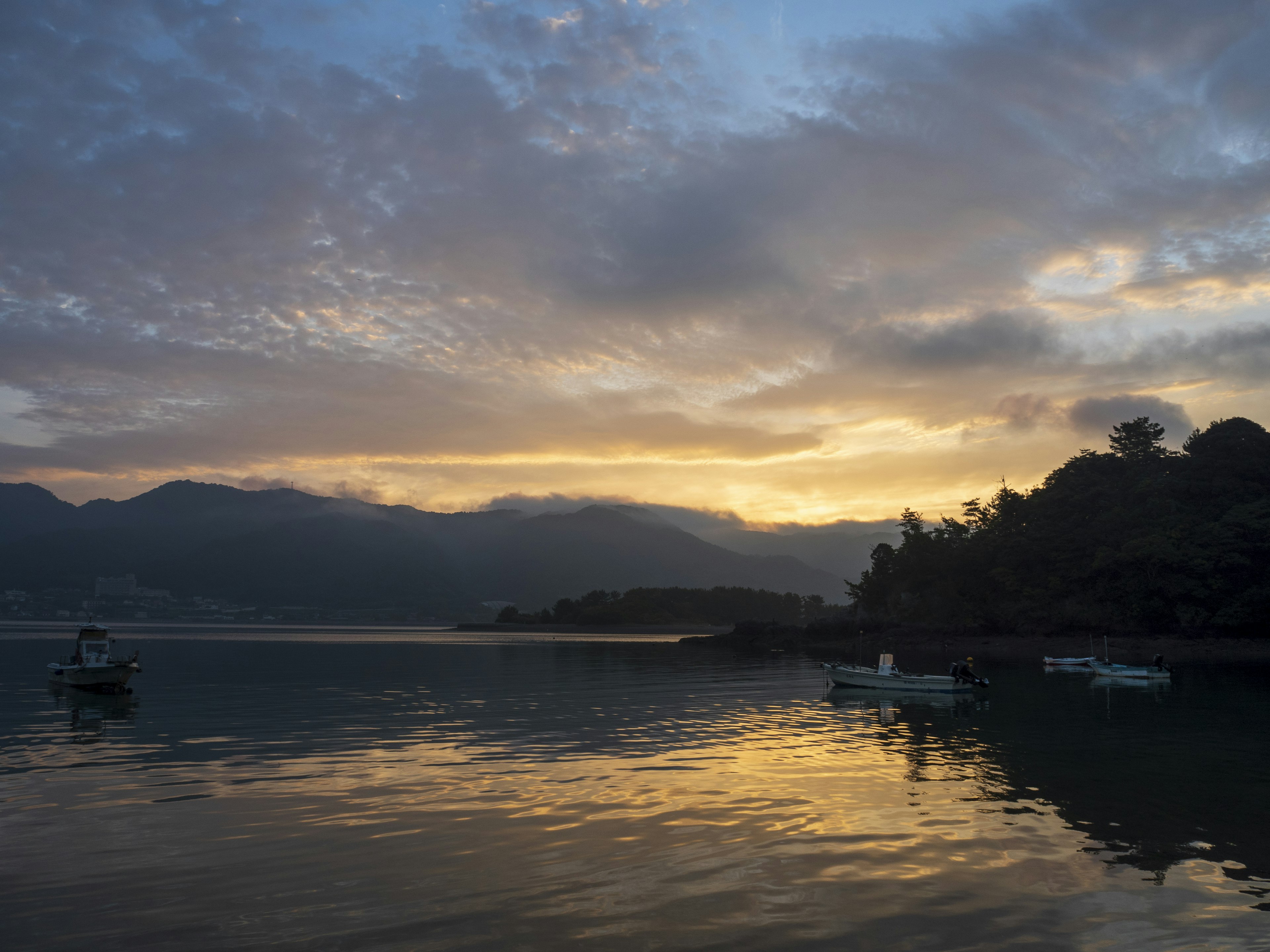 Tramonto suggestivo che si riflette su un lago con barche che galleggiano