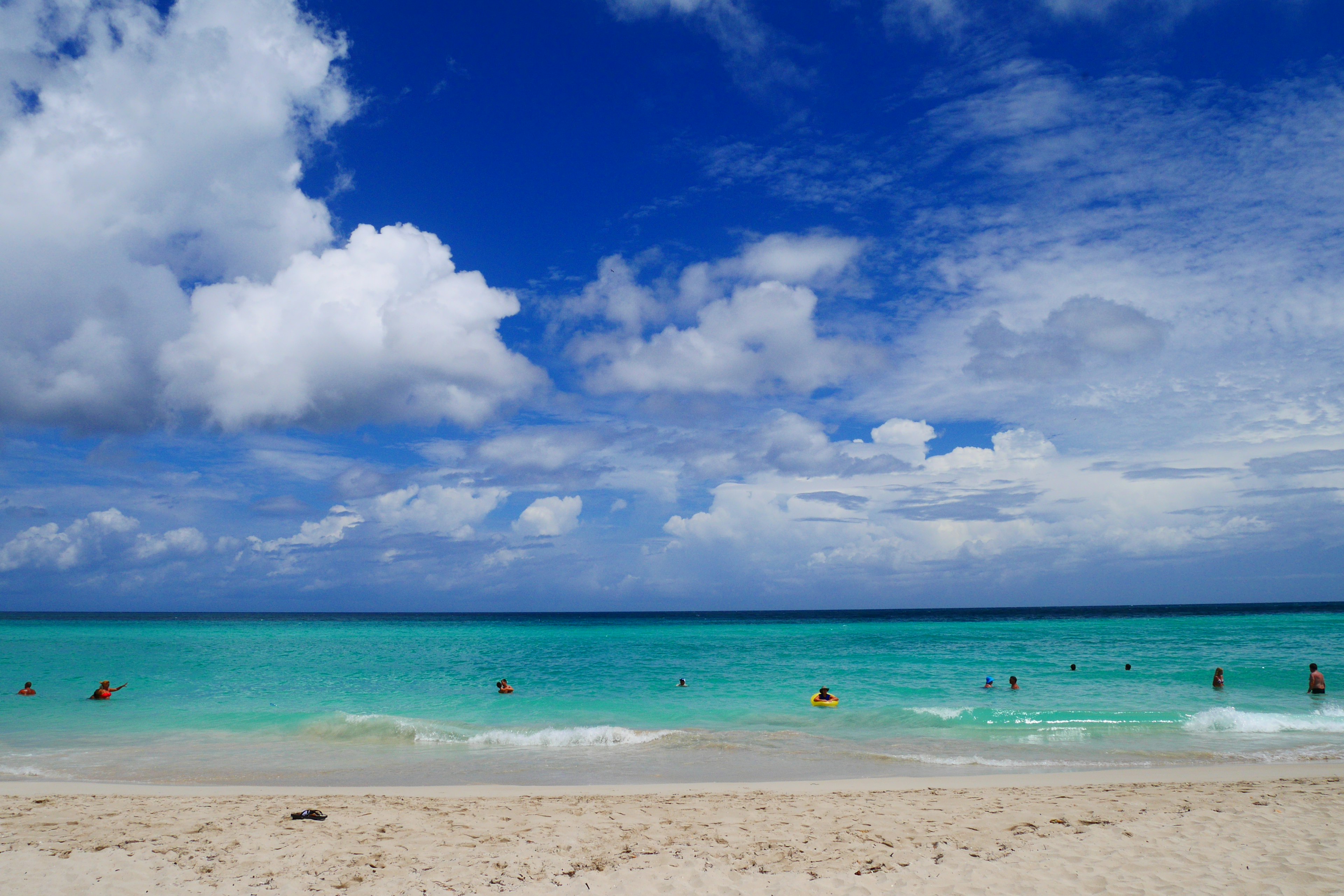 Une vue de plage pittoresque avec des eaux bleues et du sable blanc avec des gens profitant du soleil