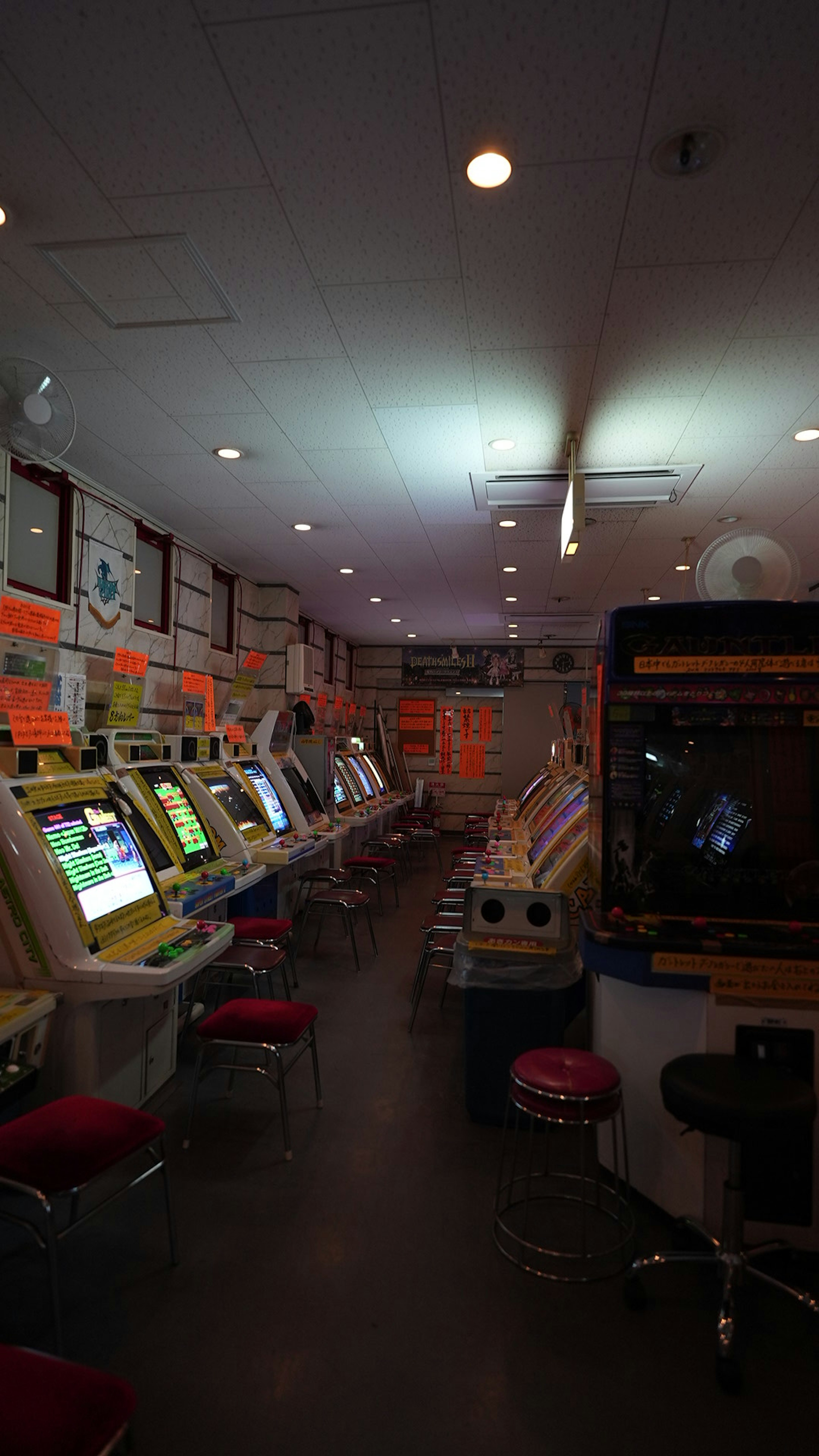 Interior de una sala de juegos con máquinas coloridas y luces fluorescentes