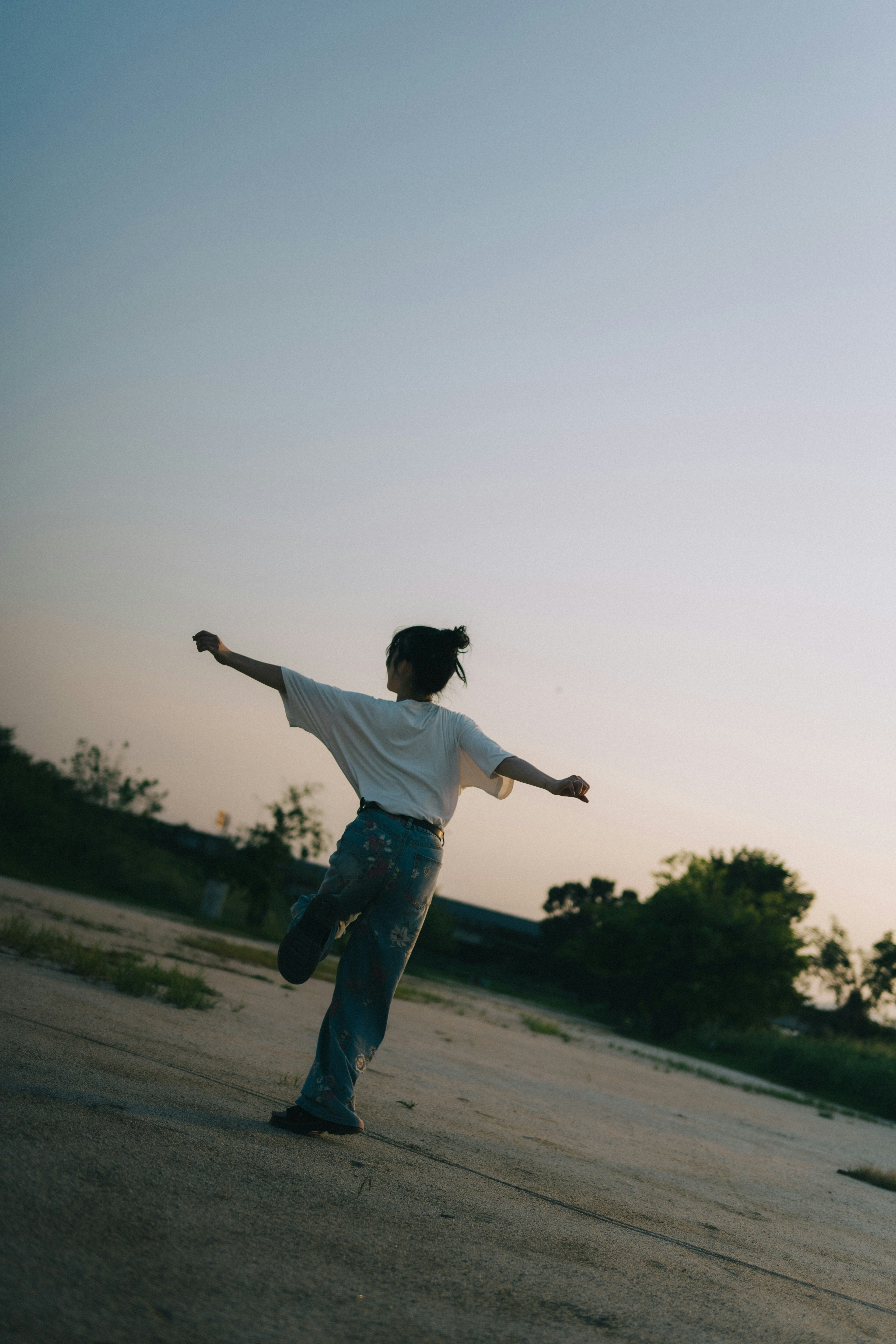 夕暮れ時に自由に踊る女性の姿