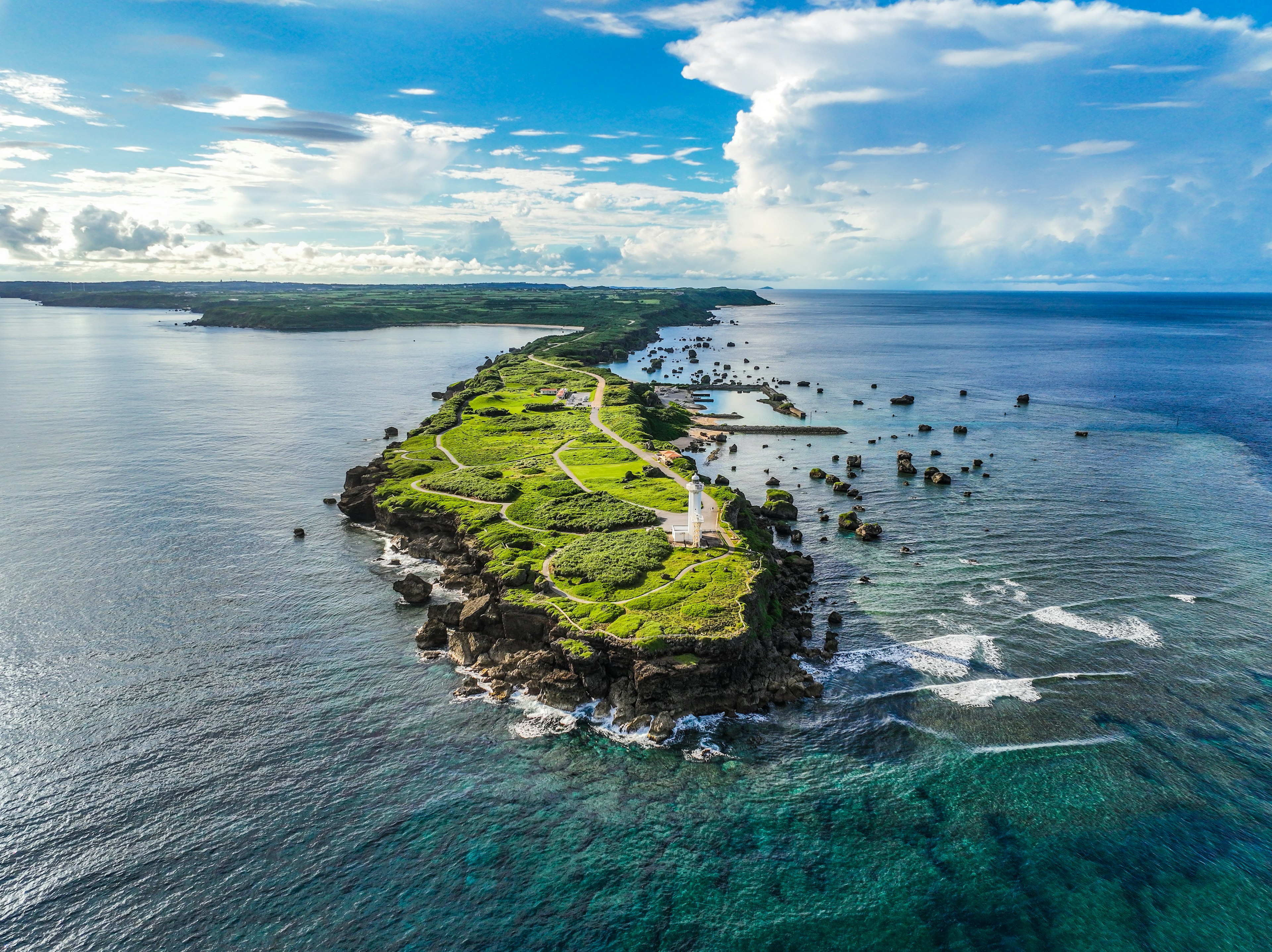 Pemandangan udara dari pulau hijau subur dikelilingi lautan biru yang cerah