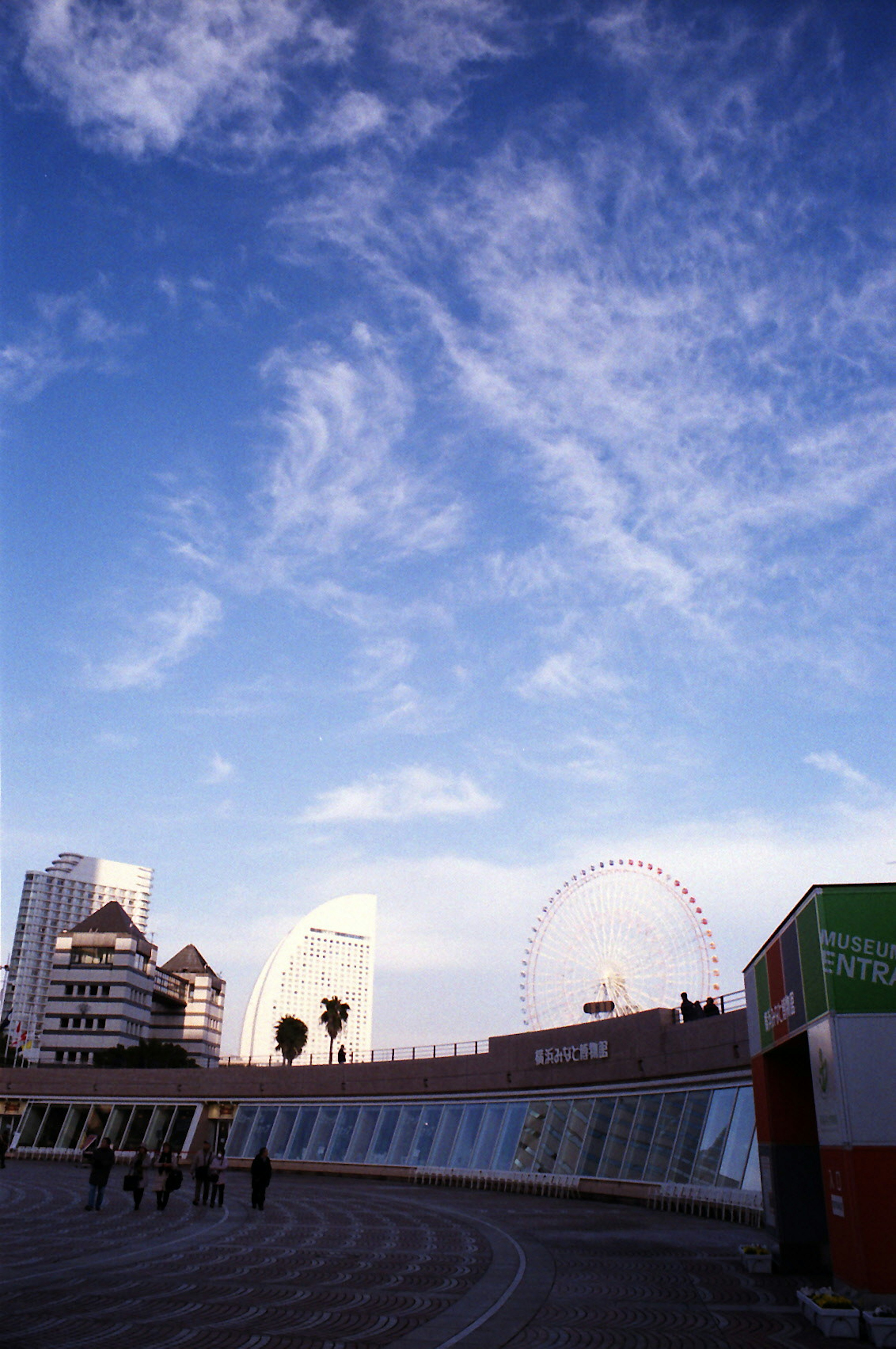 Paysage urbain avec de grands bâtiments et une grande roue sous un ciel bleu avec des nuages