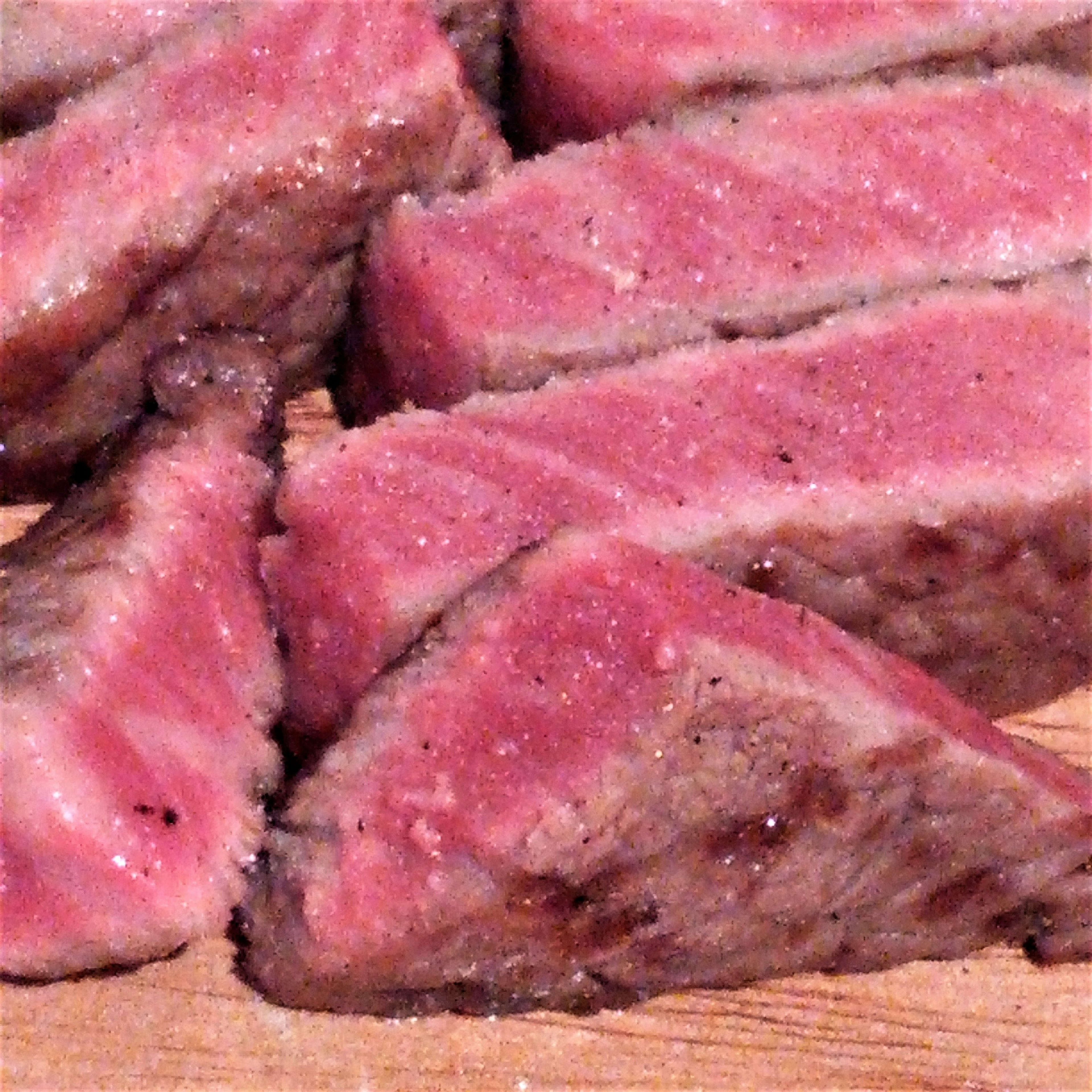 Slices of juicy steak arranged on a wooden board