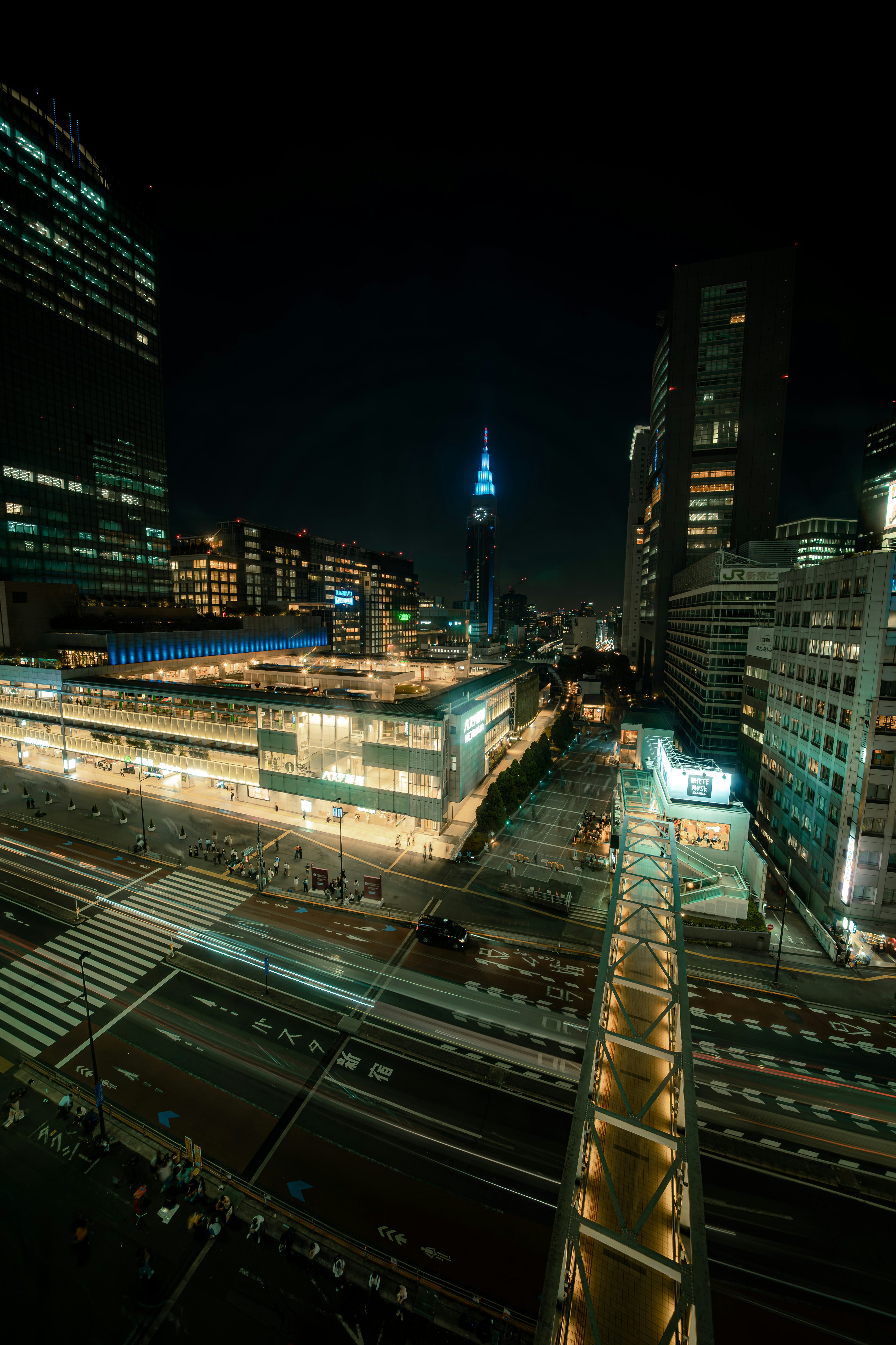 夜の都市の景観 東京スカイツリーが青く光る 高層ビルと交通の交差点が見える