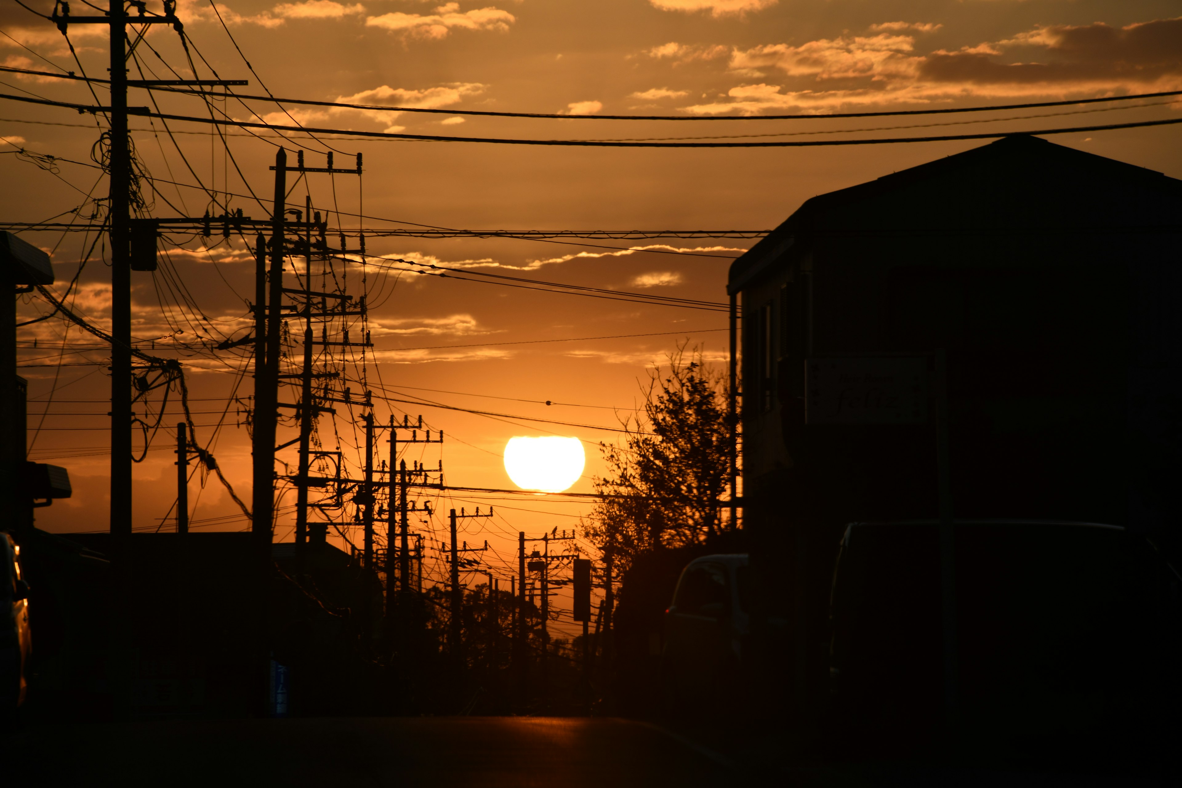 Silhouette de bâtiments et de lignes électriques contre un ciel de coucher de soleil