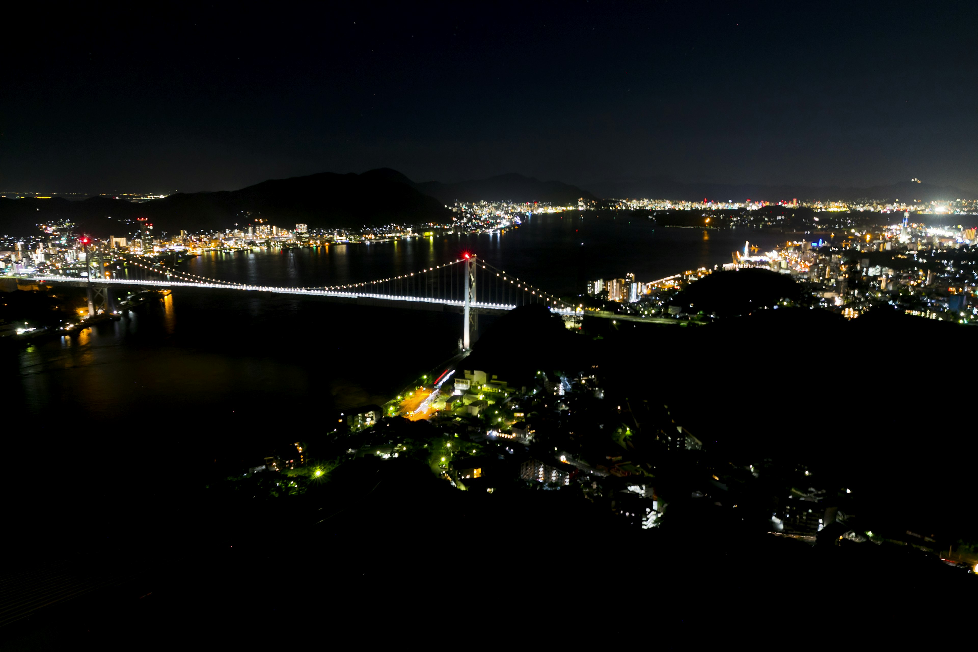 Vista nocturna de un puente y luces de la ciudad