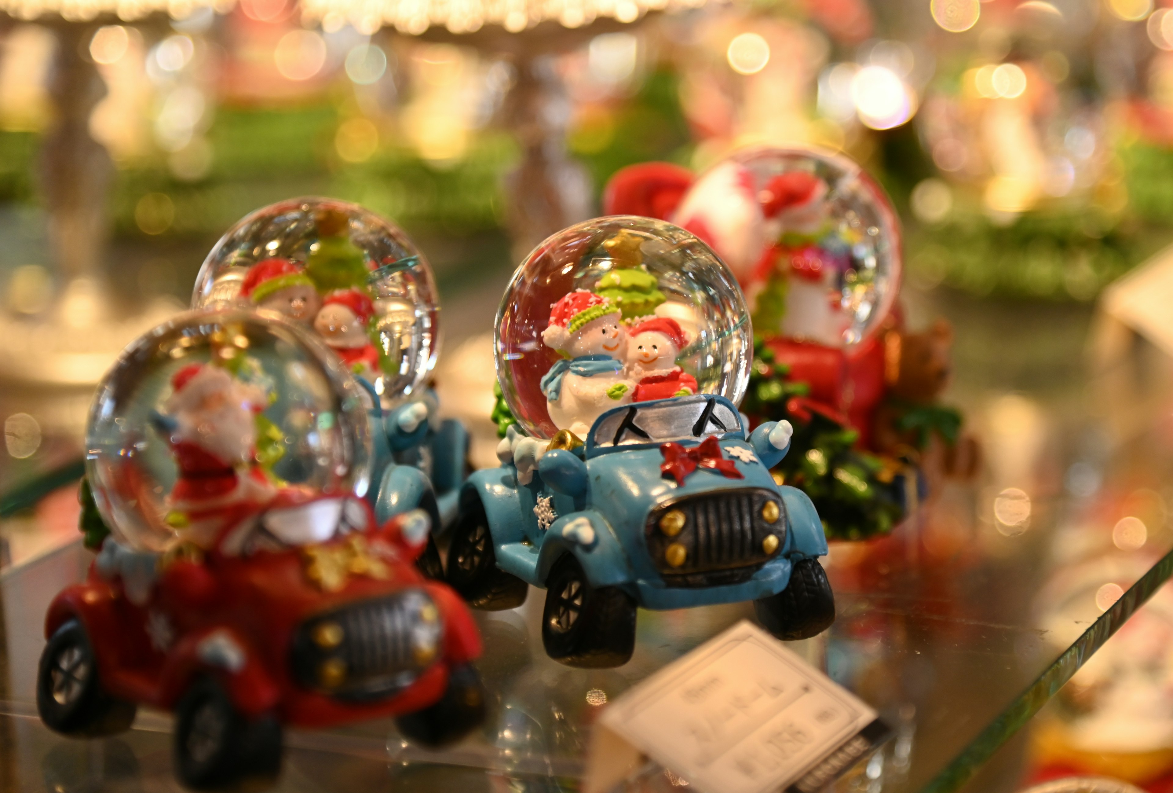 Vitrine de globes de neige avec le Père Noël dans des voitures