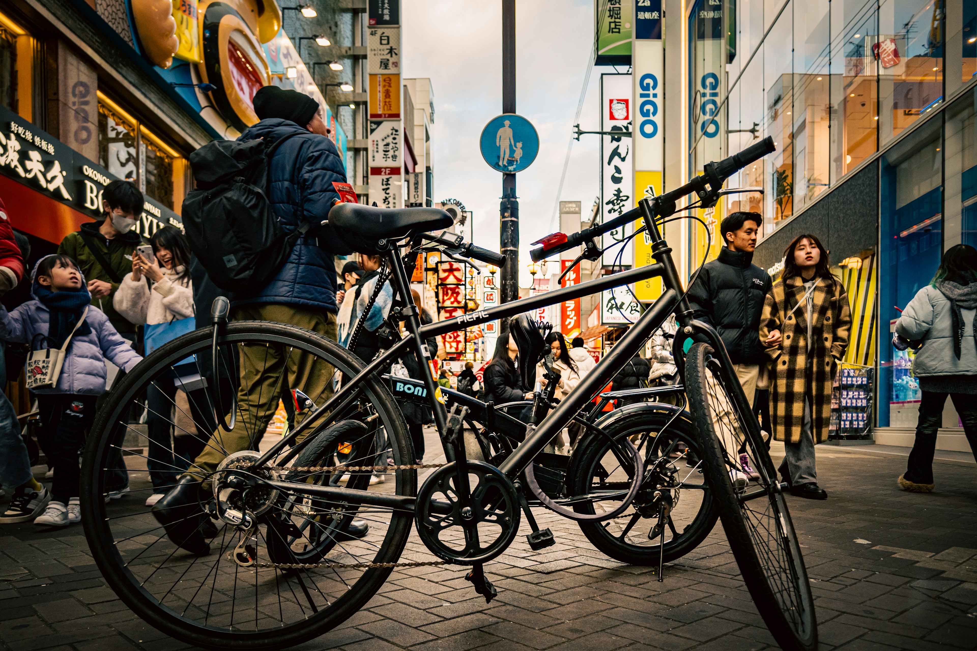 Bicycle in a bustling street scene with pedestrians and colorful shop signs