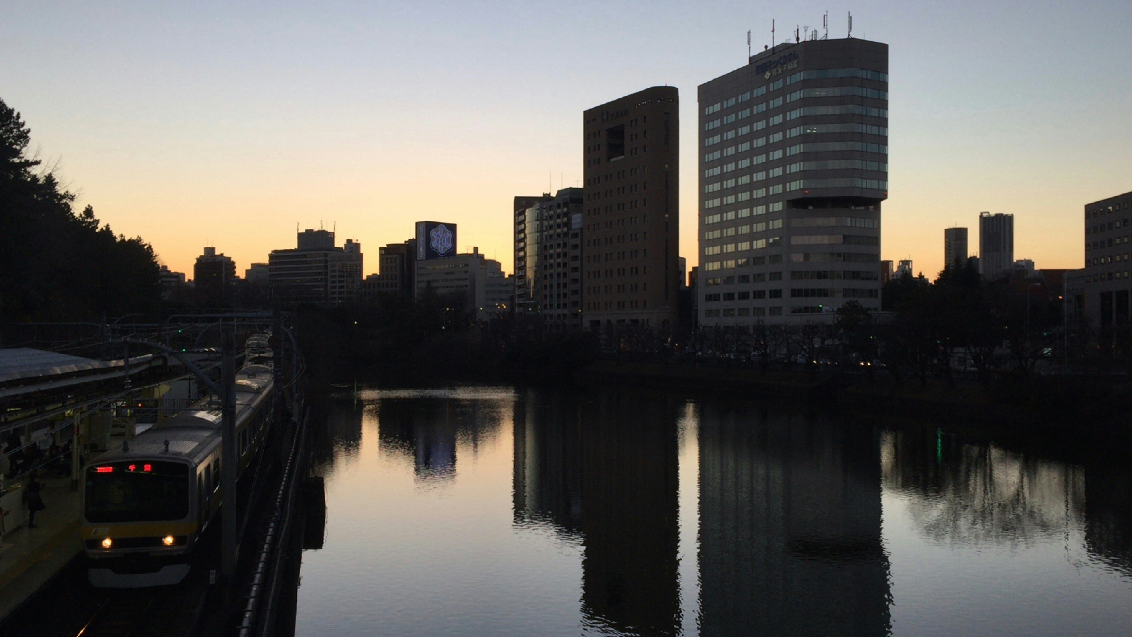 Paisaje urbano al atardecer con reflejo en el río