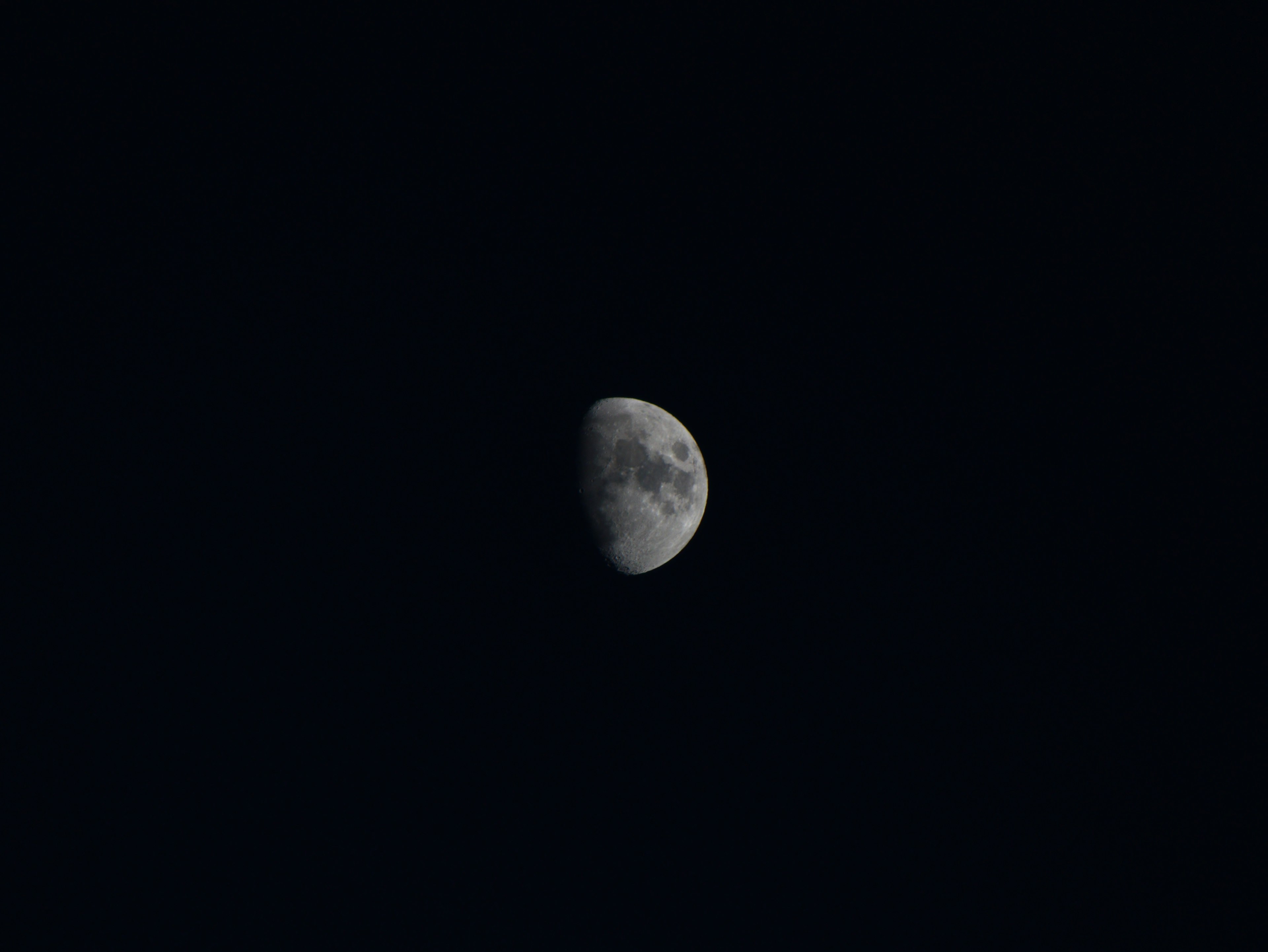 Lune en croissant visible dans un ciel sombre