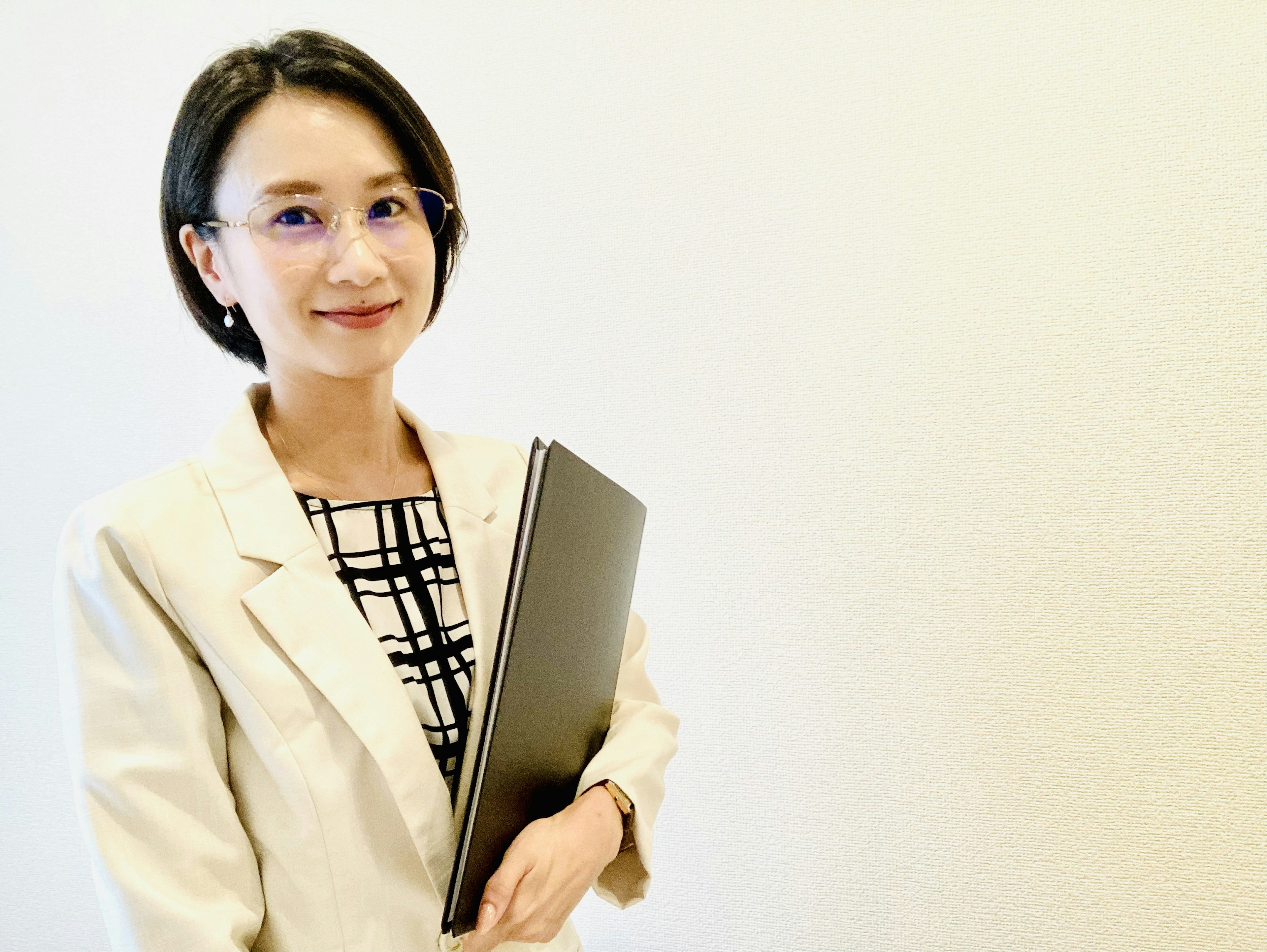 A woman in a business suit holding a laptop