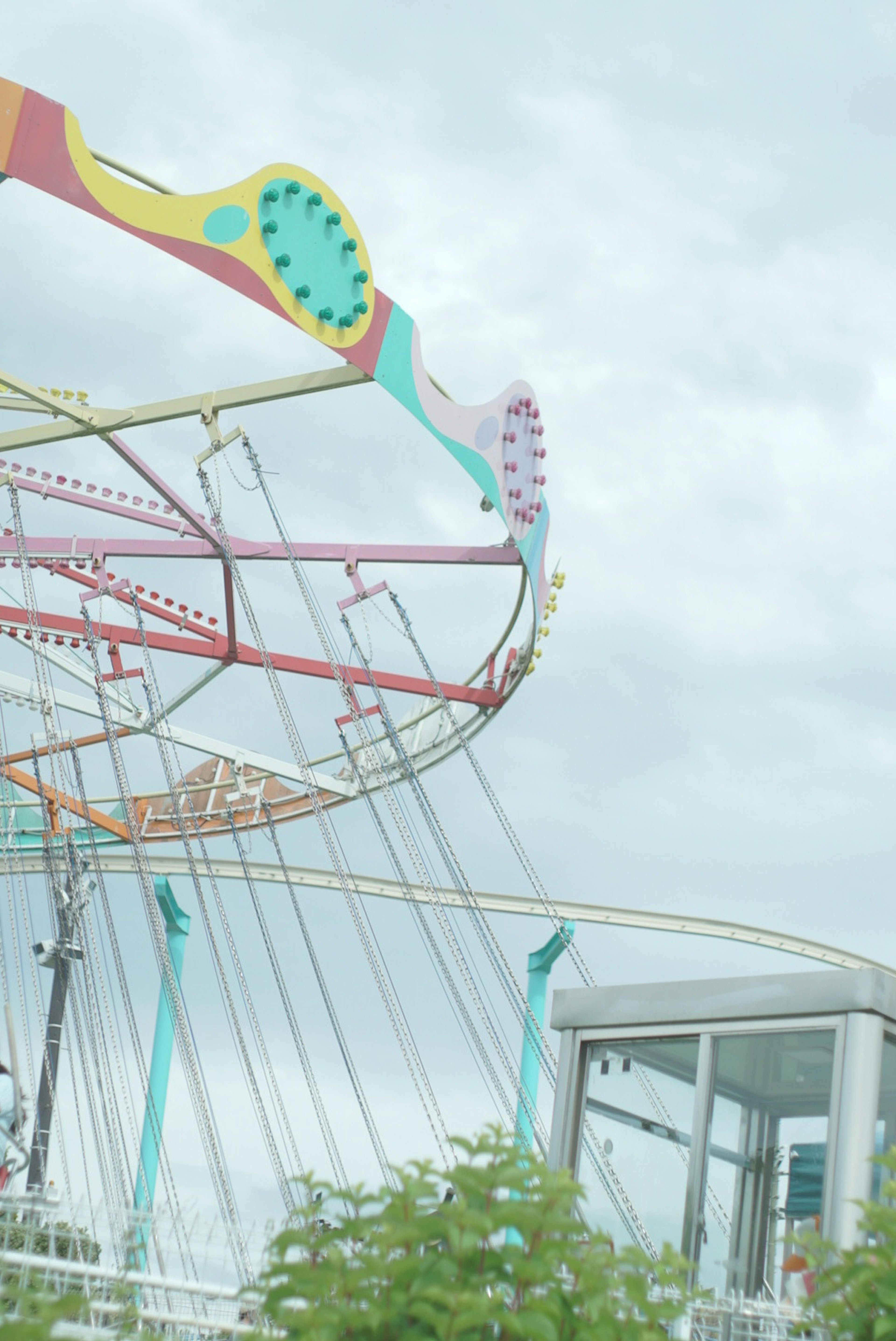 Part of a colorful amusement park ride with a cloudy sky