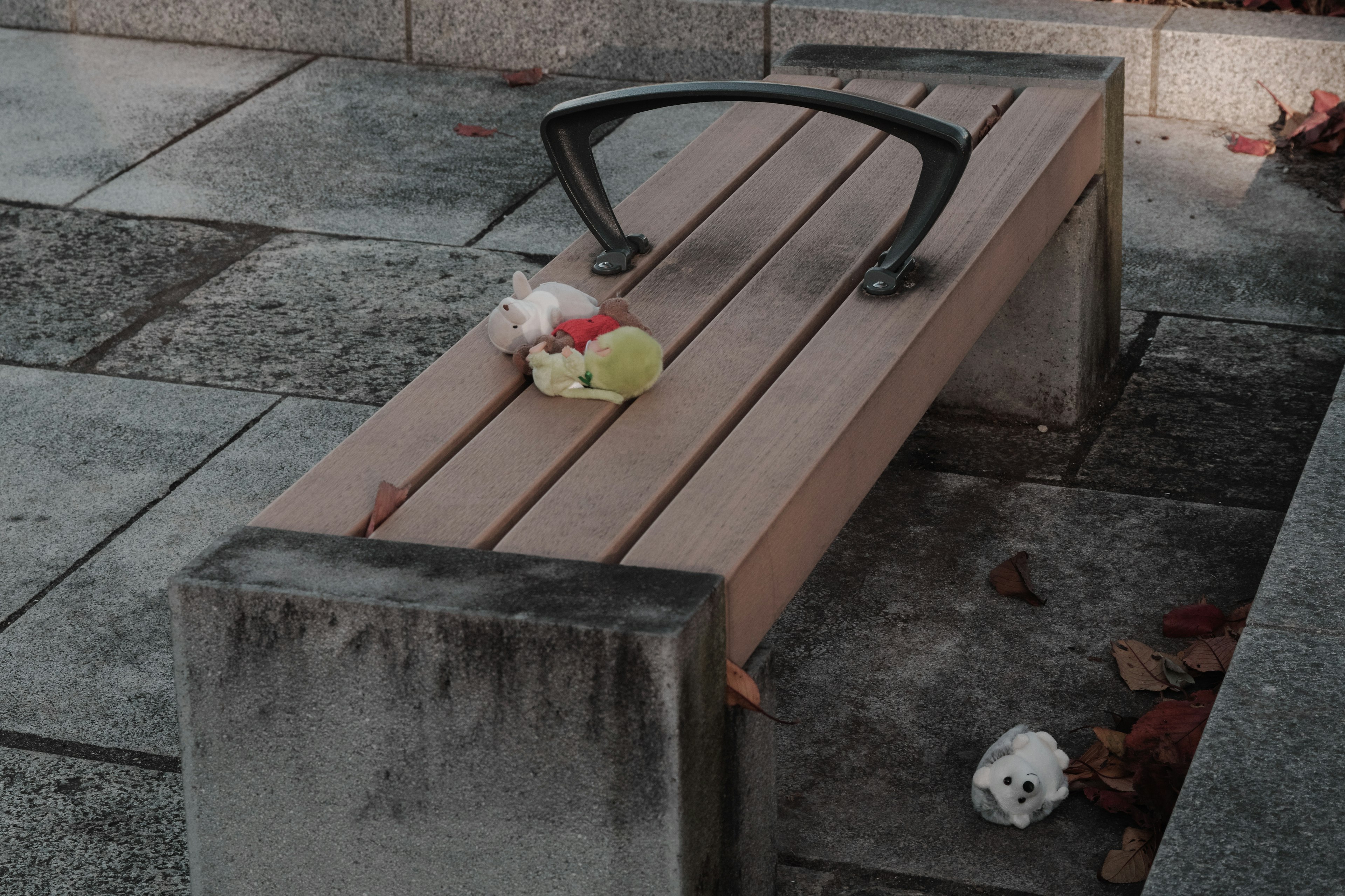 A park bench with food scraps and fallen leaves